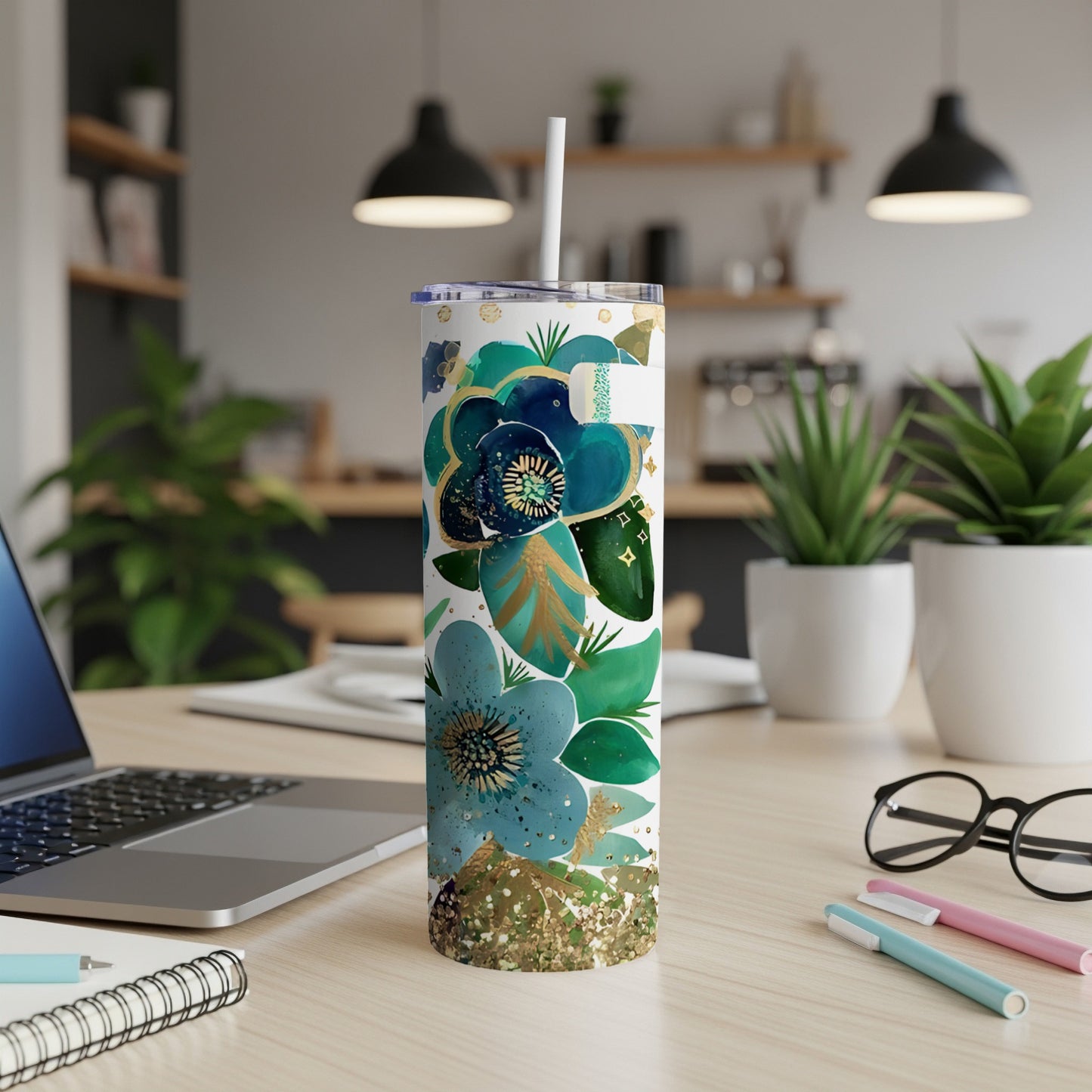 Tall tumbler with blue and green floral design and gold glitter.