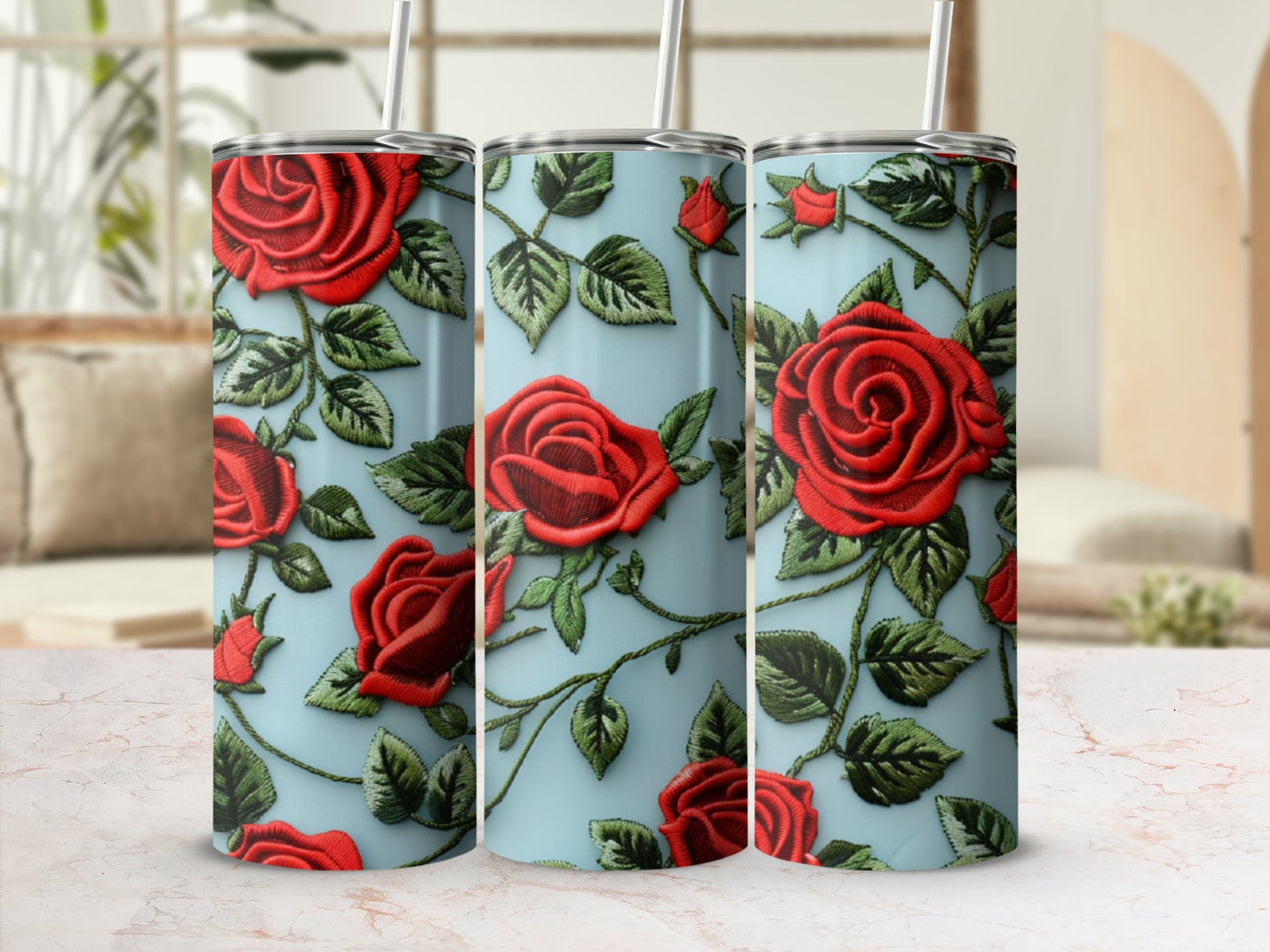 Three tumblers with a red rose embroidery design on a light blue background.