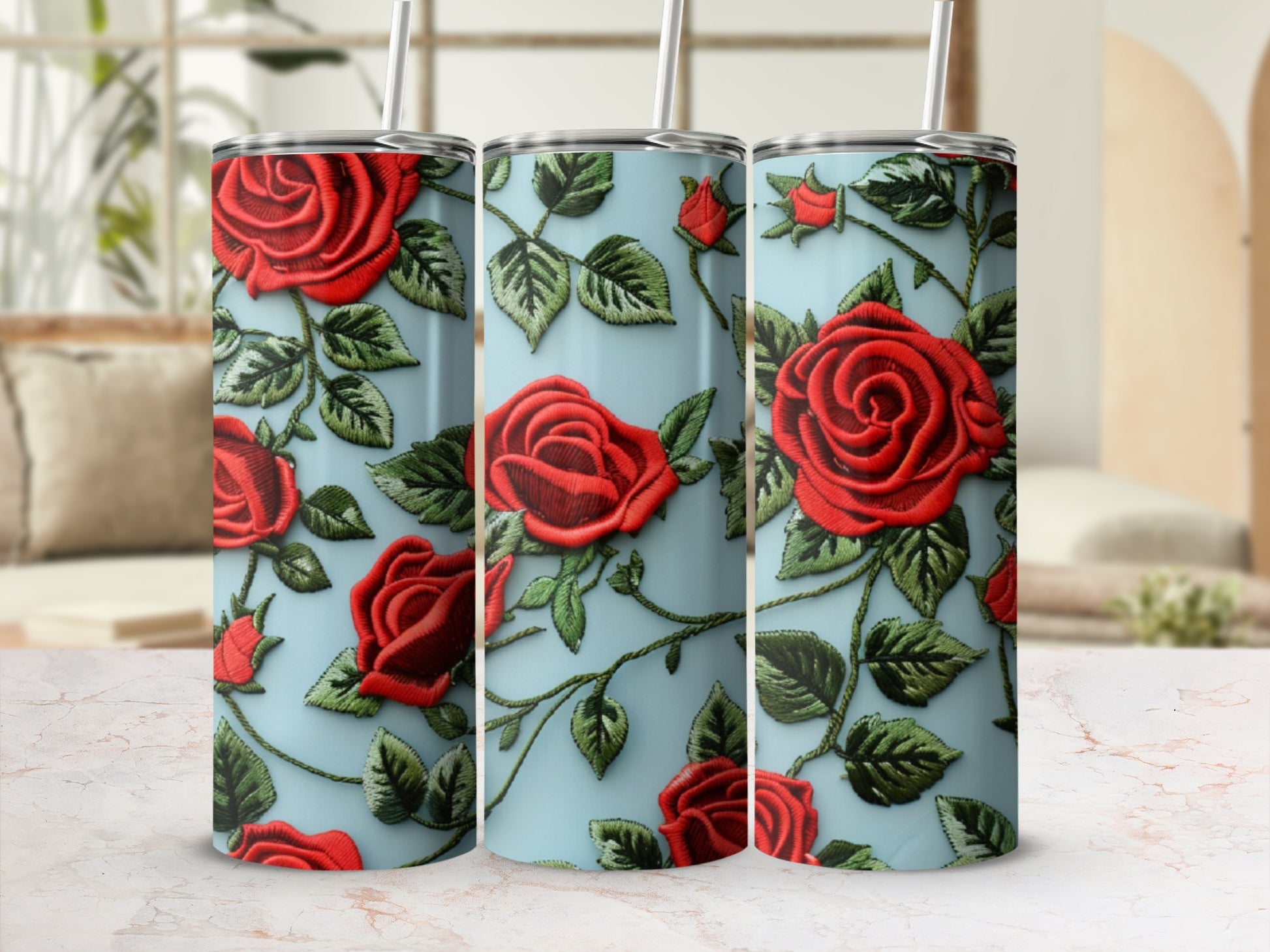 Three tumblers with a red rose embroidery design on a light blue background.