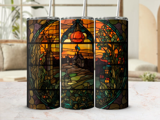 Stained glass tumbler with a spooky fall scene and a pumpkin.