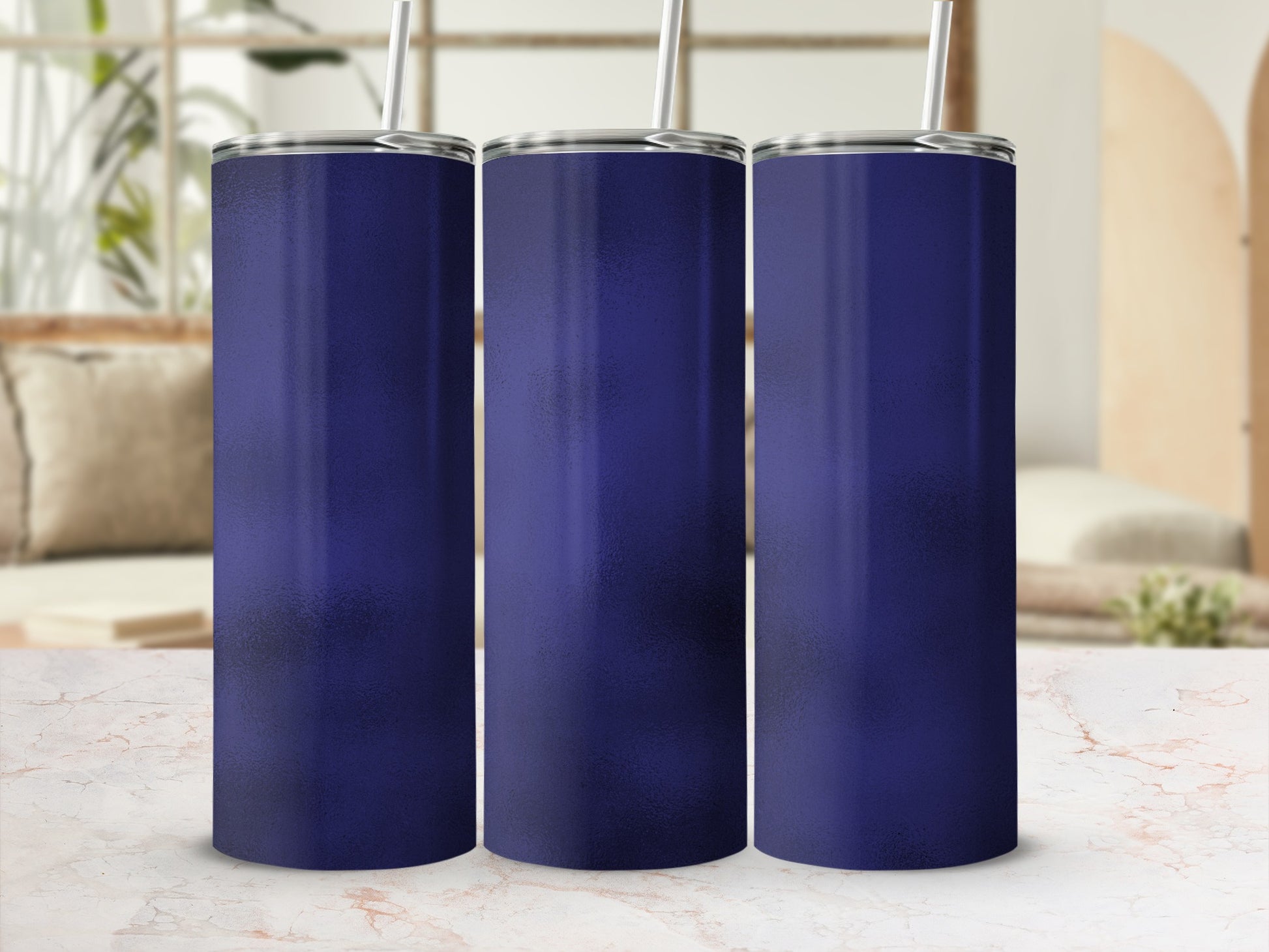Three dark blue tumblers with silver lids and straws arranged side-by-side.