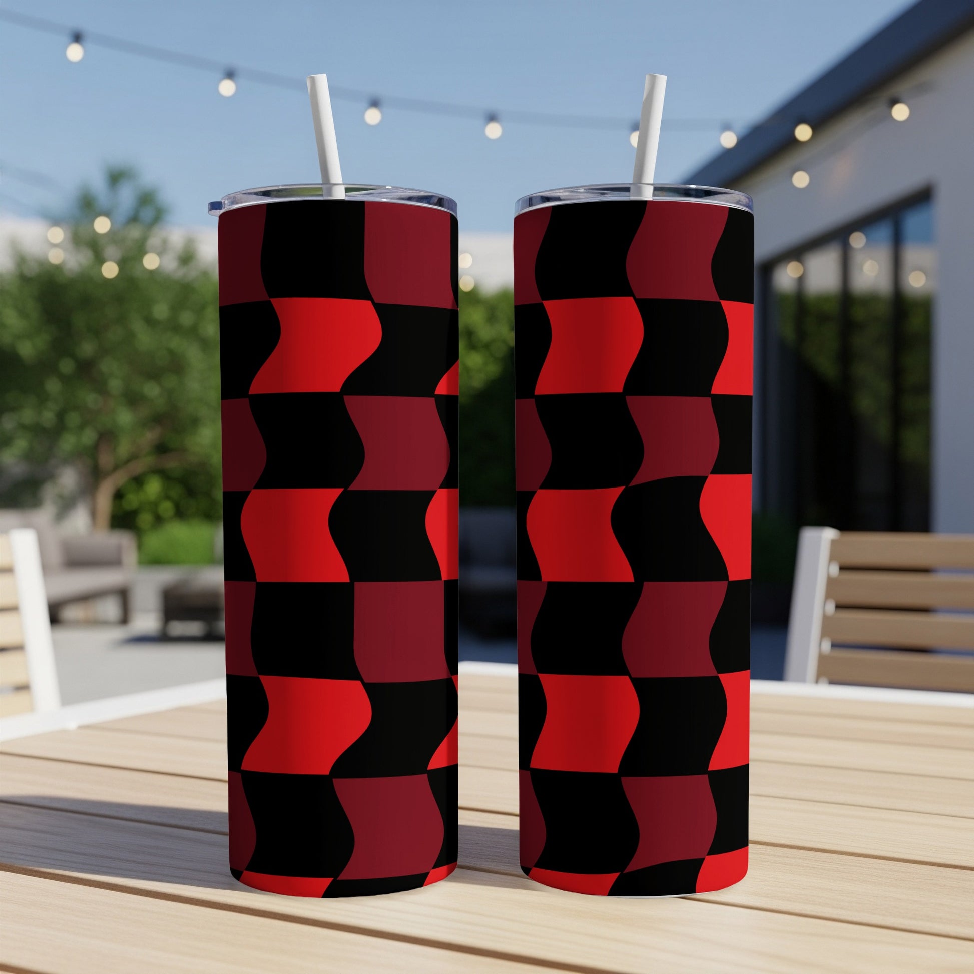 Two tumblers with a red and black checkered wavy pattern on a wooden table.