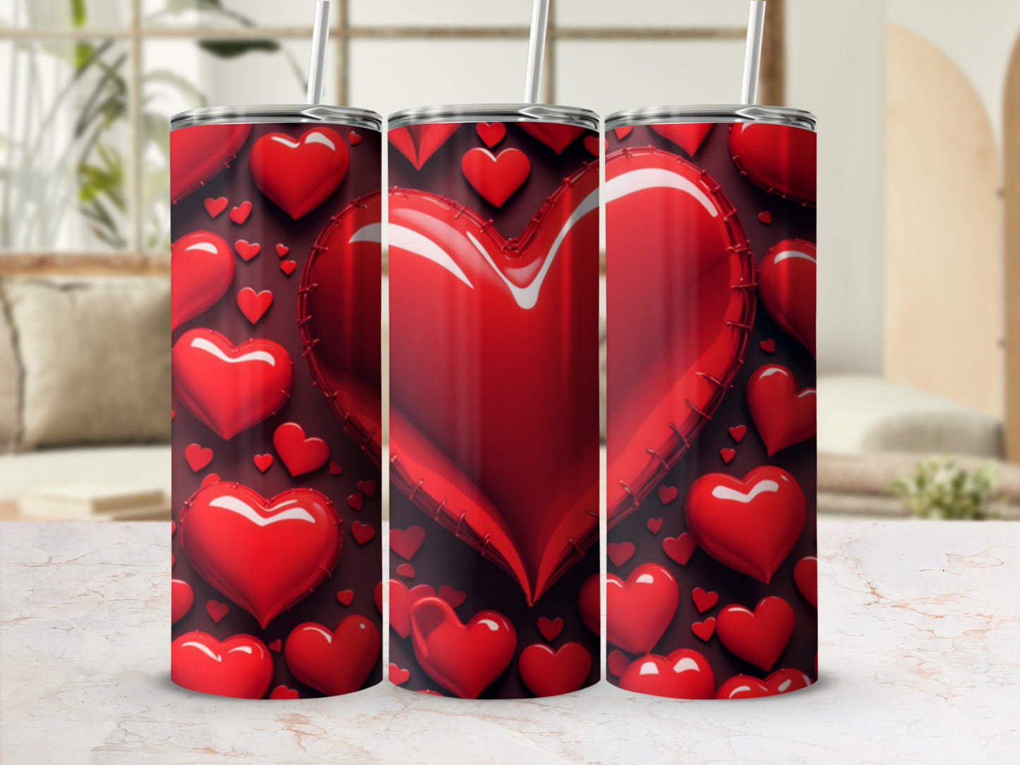 Three tumblers with a red heart pattern and straws, displayed on a counter.