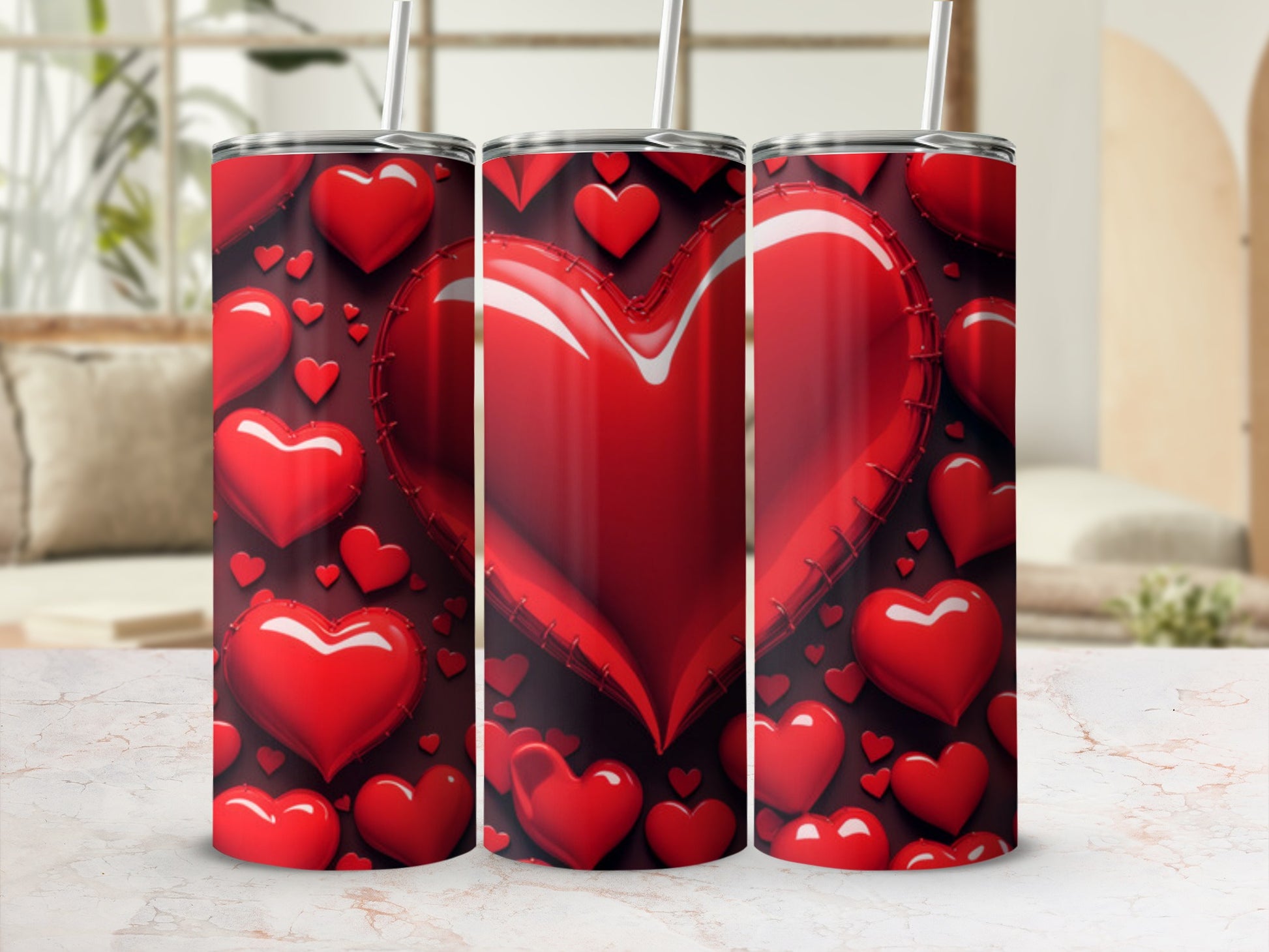 Three tumblers with a red heart pattern and straws, displayed on a counter.