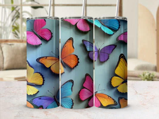Three tumblers featuring colorful butterflies on a gradient blue background.