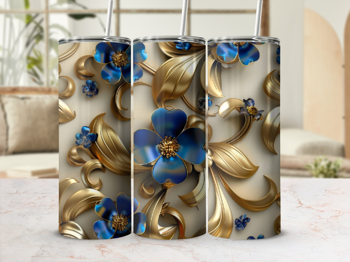 Gold floral pattern on a tumbler with blue flowers and straw.