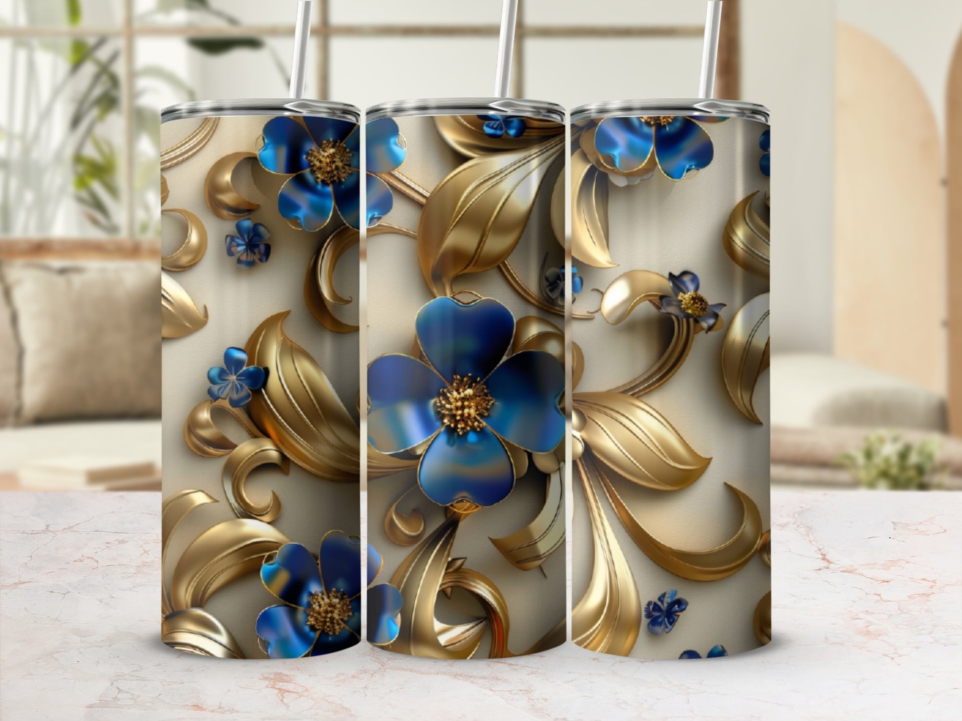 Gold floral pattern on a tumbler with blue flowers and straw.