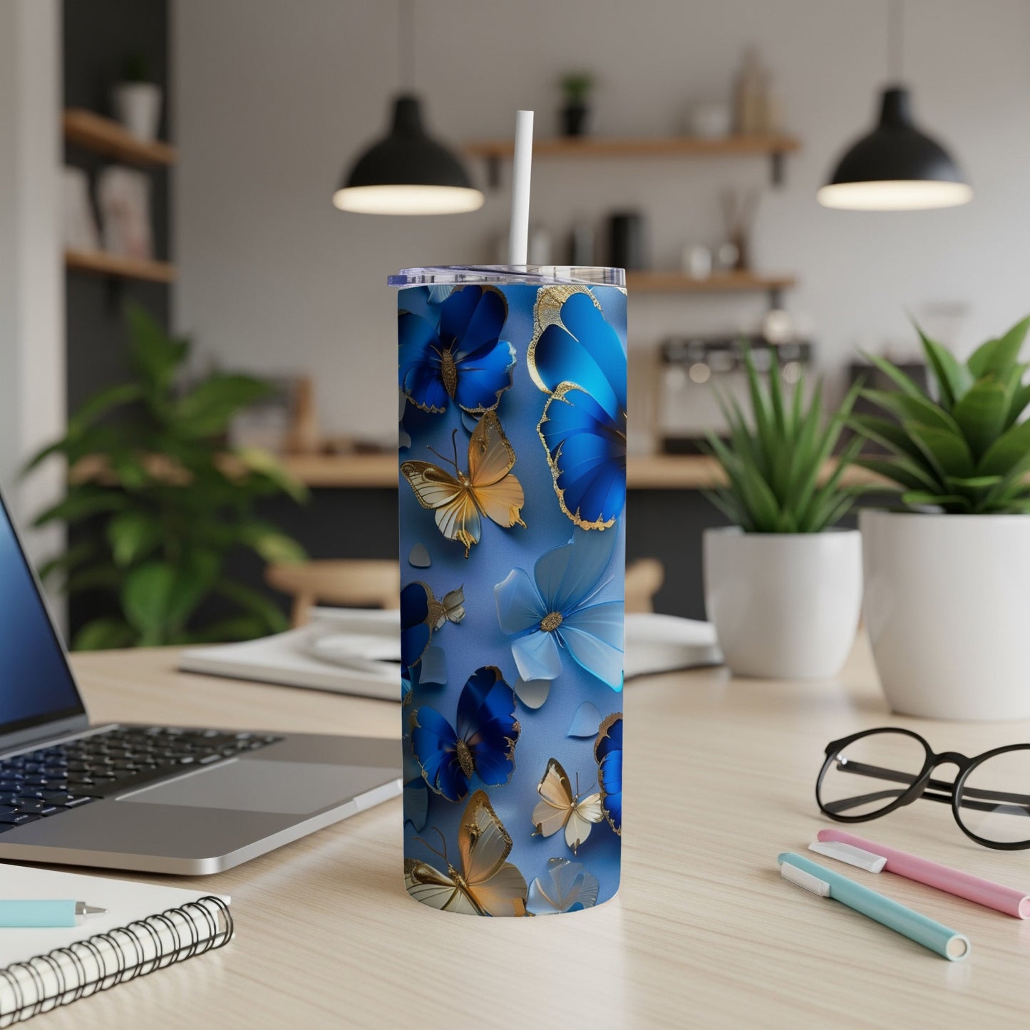 Blue tumbler with gold and blue butterfly and floral design.