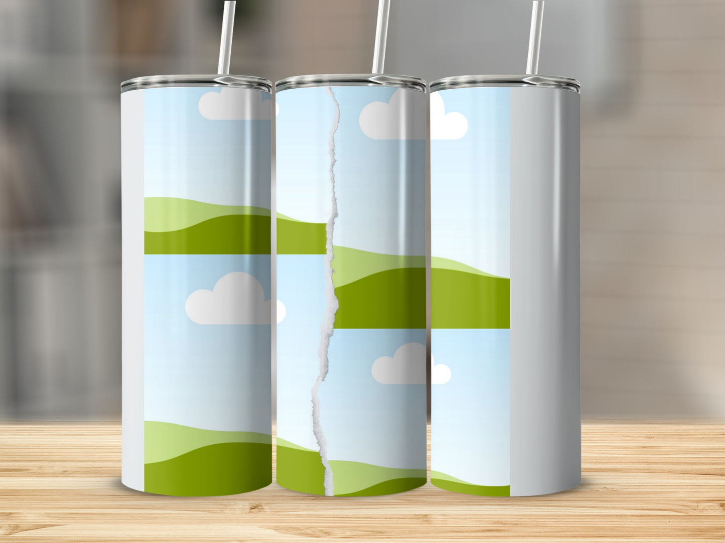 Three tumblers with a torn landscape graphic on a wooden surface.