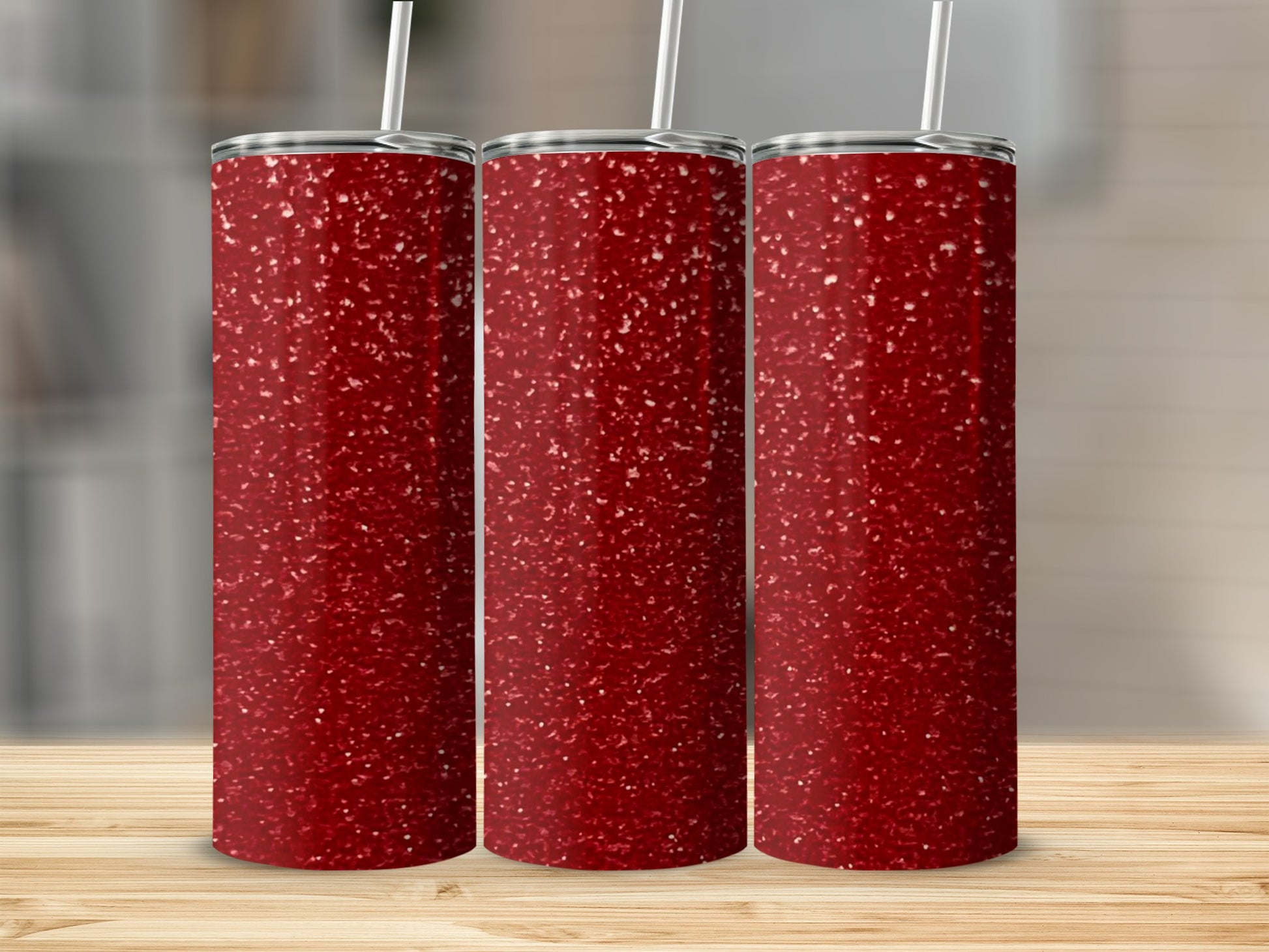 Three tall, slender tumblers with a red glitter design on a wooden surface.