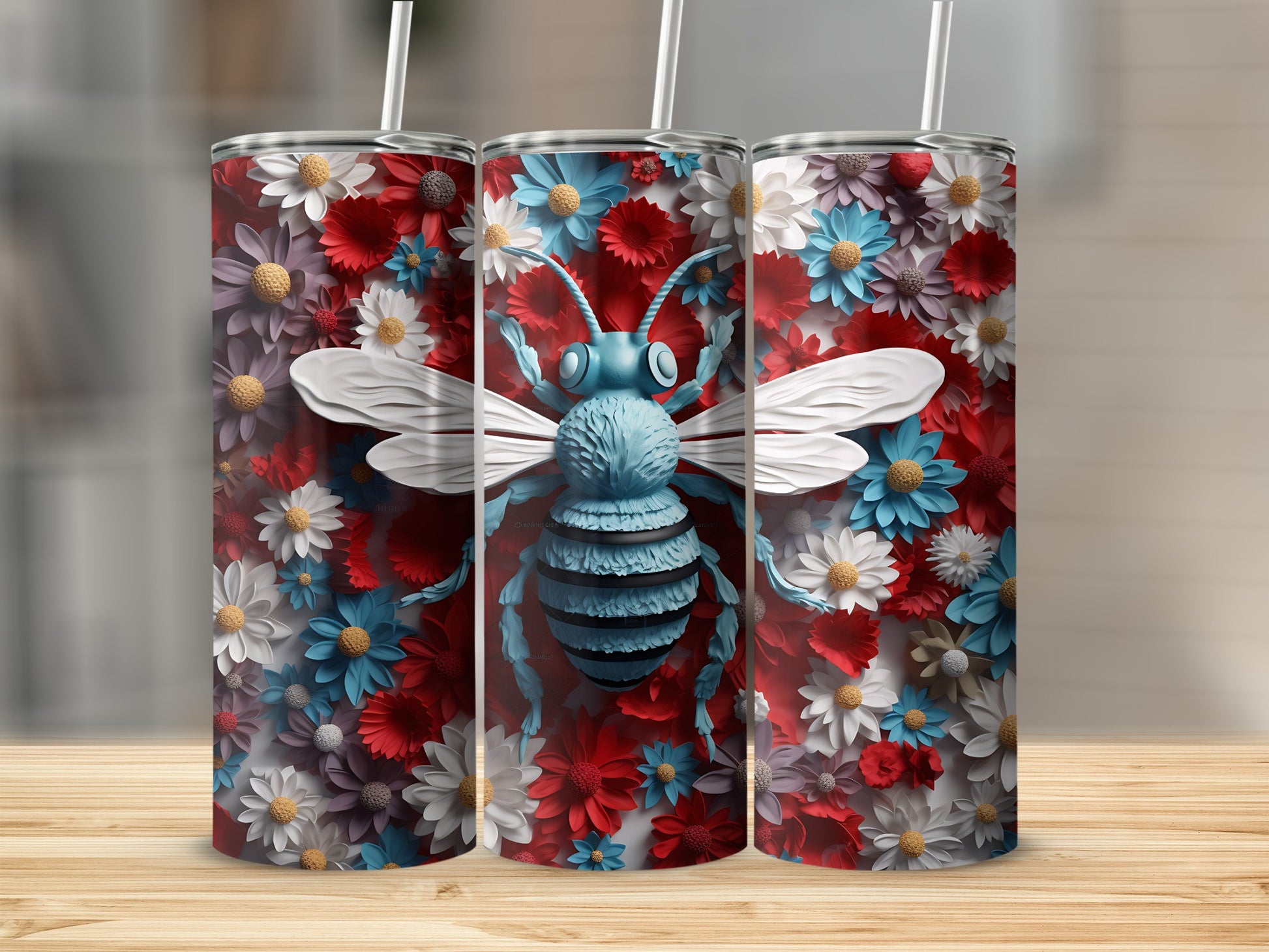 Three tumblers featuring a blue bee surrounded by red, white, and blue flowers.