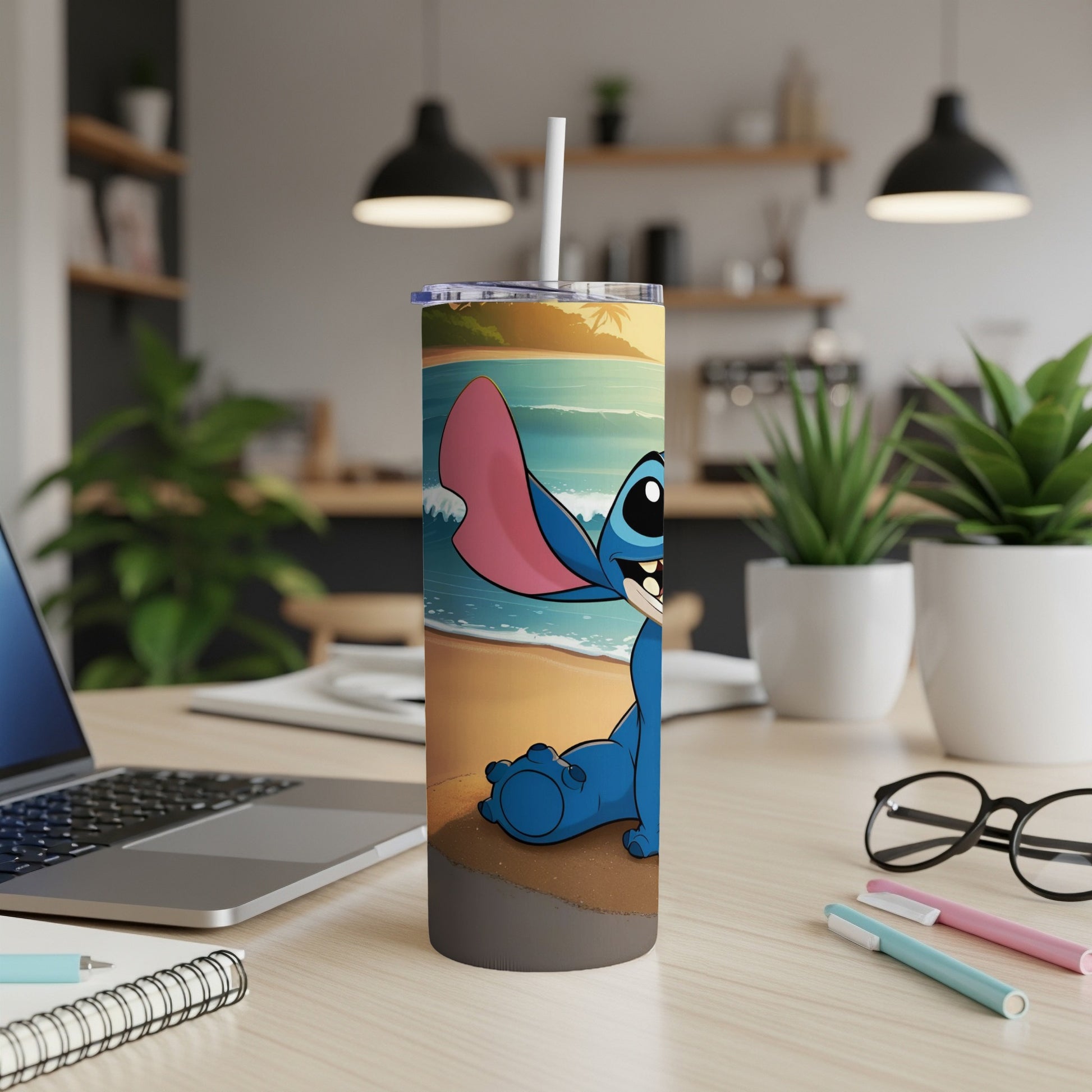 Stitch character on a beach, sitting on a desk with a laptop and glasses.