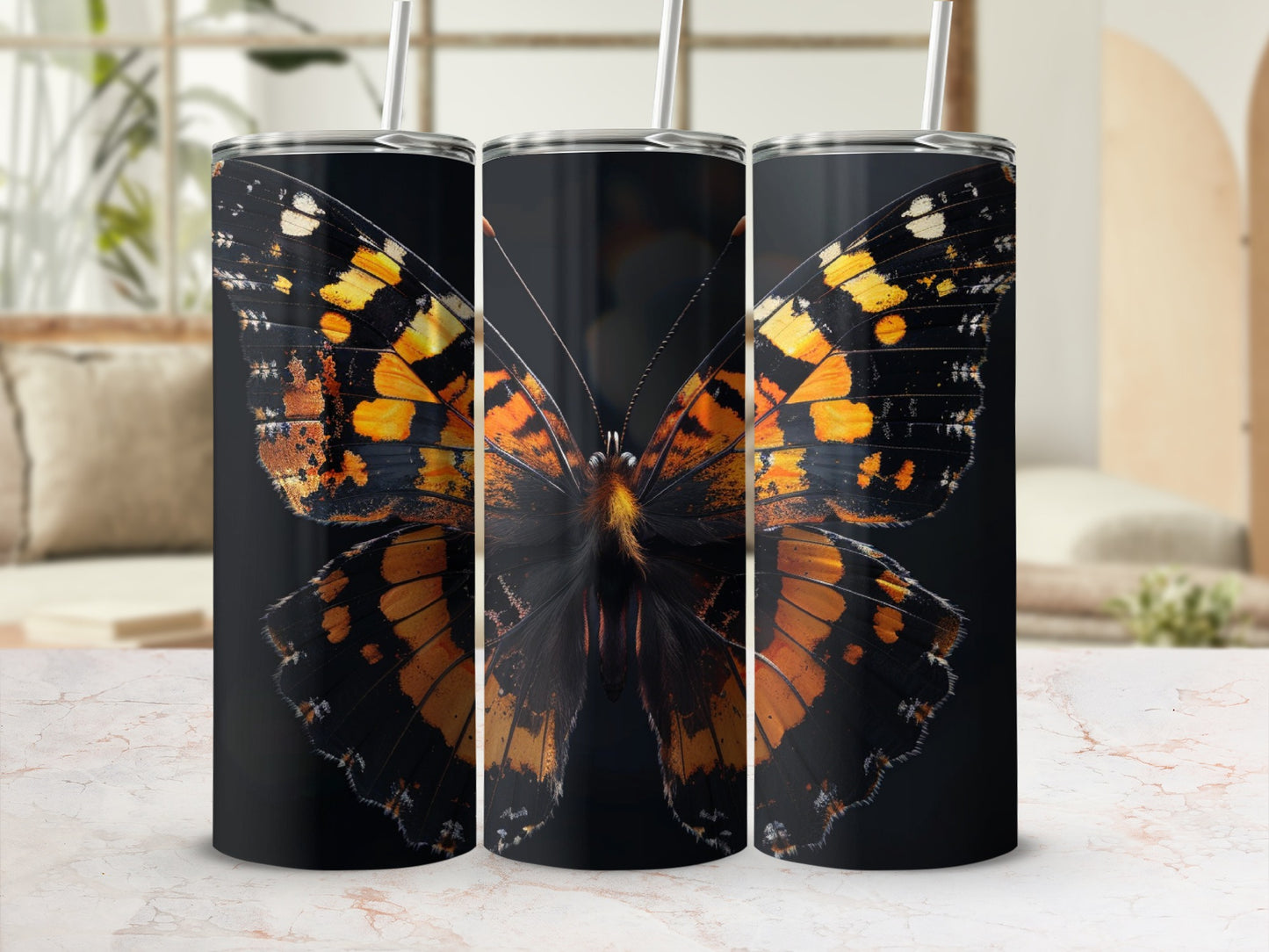 Black tumbler with a monarch butterfly design and two straws.