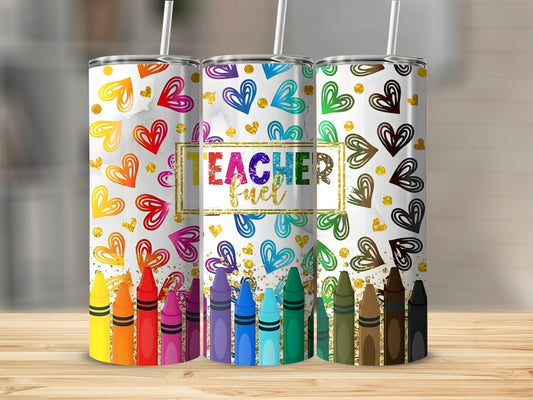 Three tumblers with colorful crayon and heart designs, one saying "Teacher Fuel."
