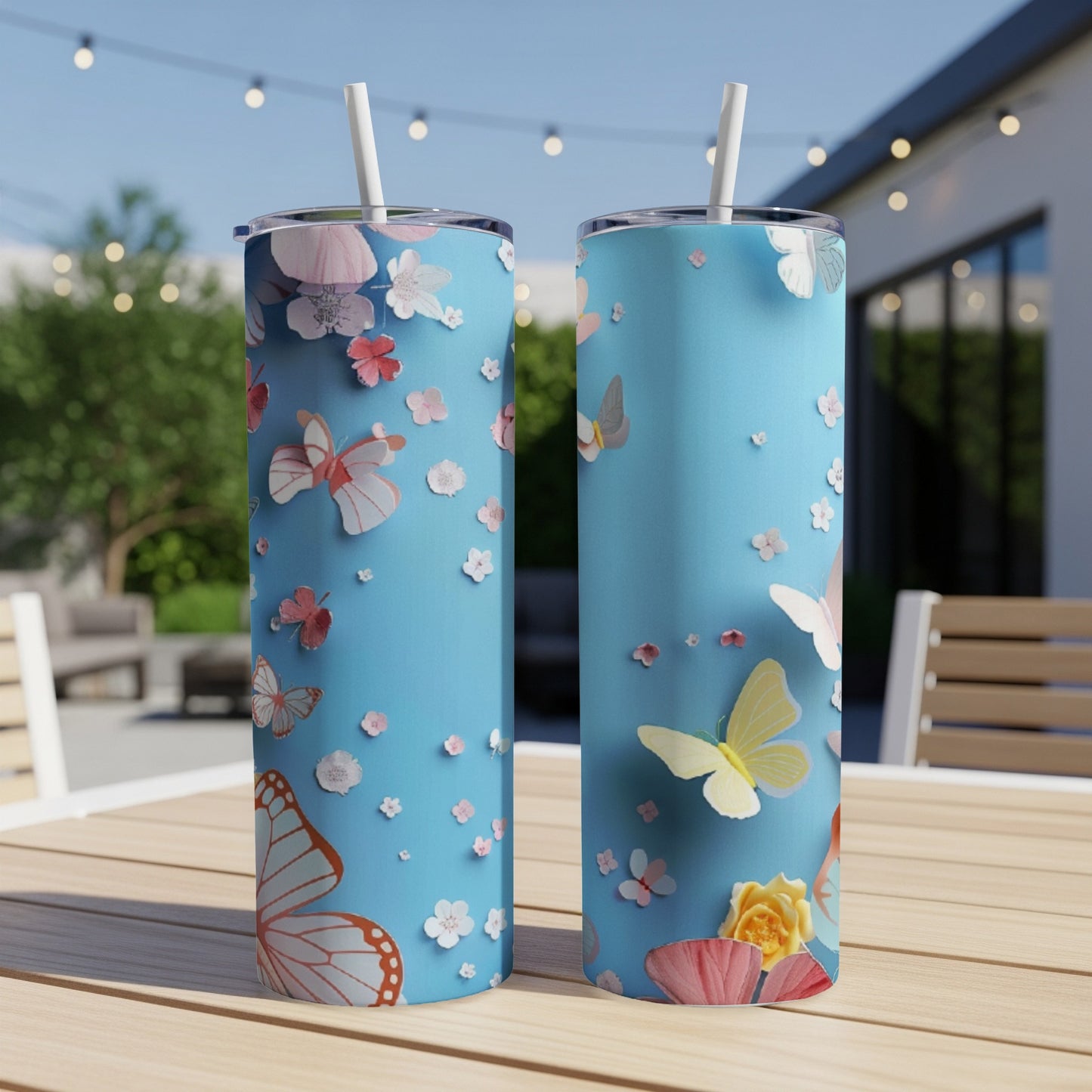 Two light blue tumblers with butterfly and floral designs sit on a table.