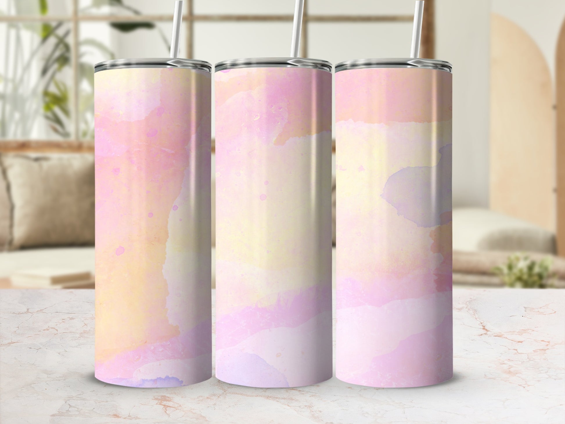 Three pink, yellow, and purple watercolor tumblers with straws.