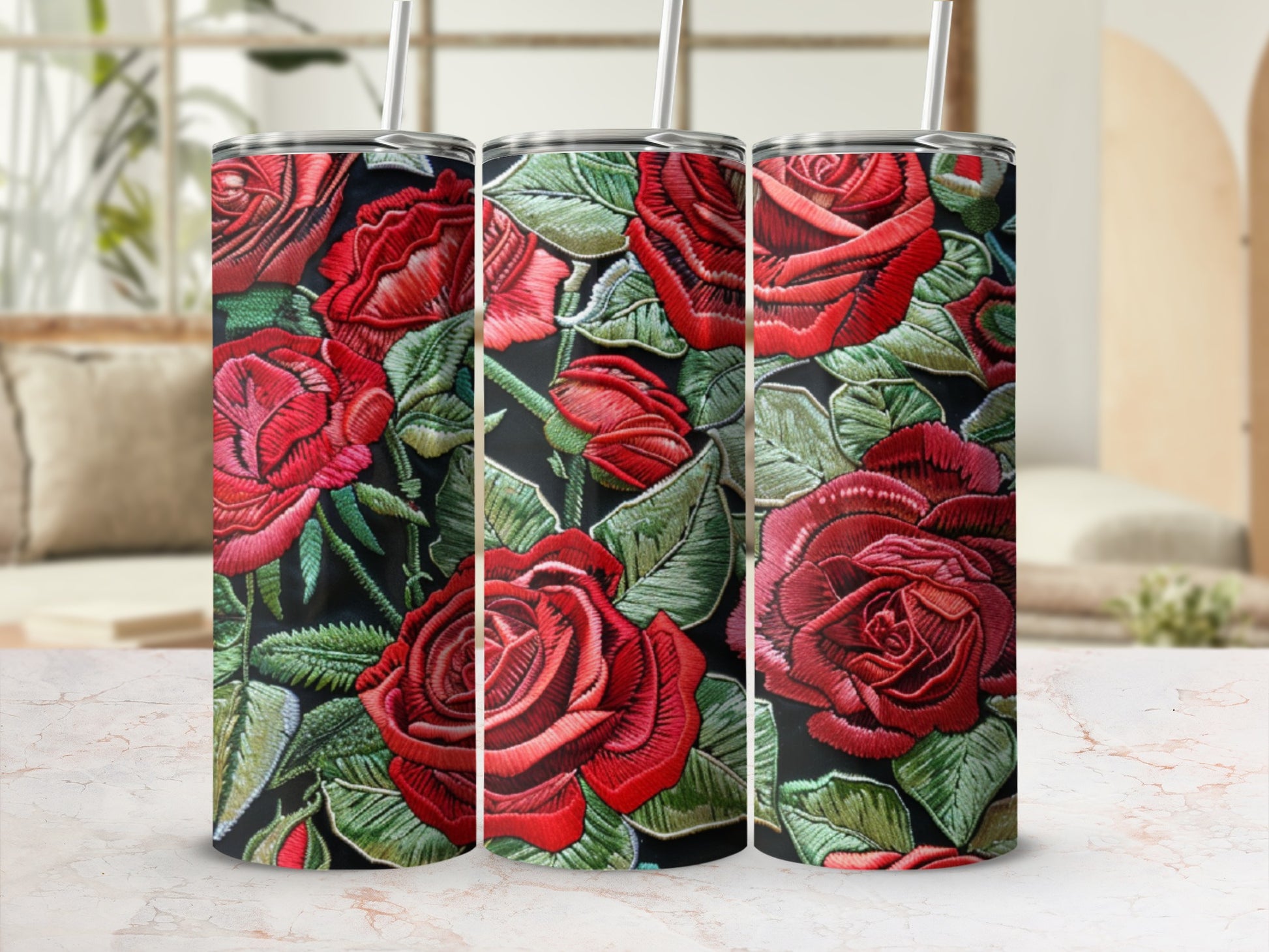 Three red embroidered roses on a dark background, on tall tumblers.