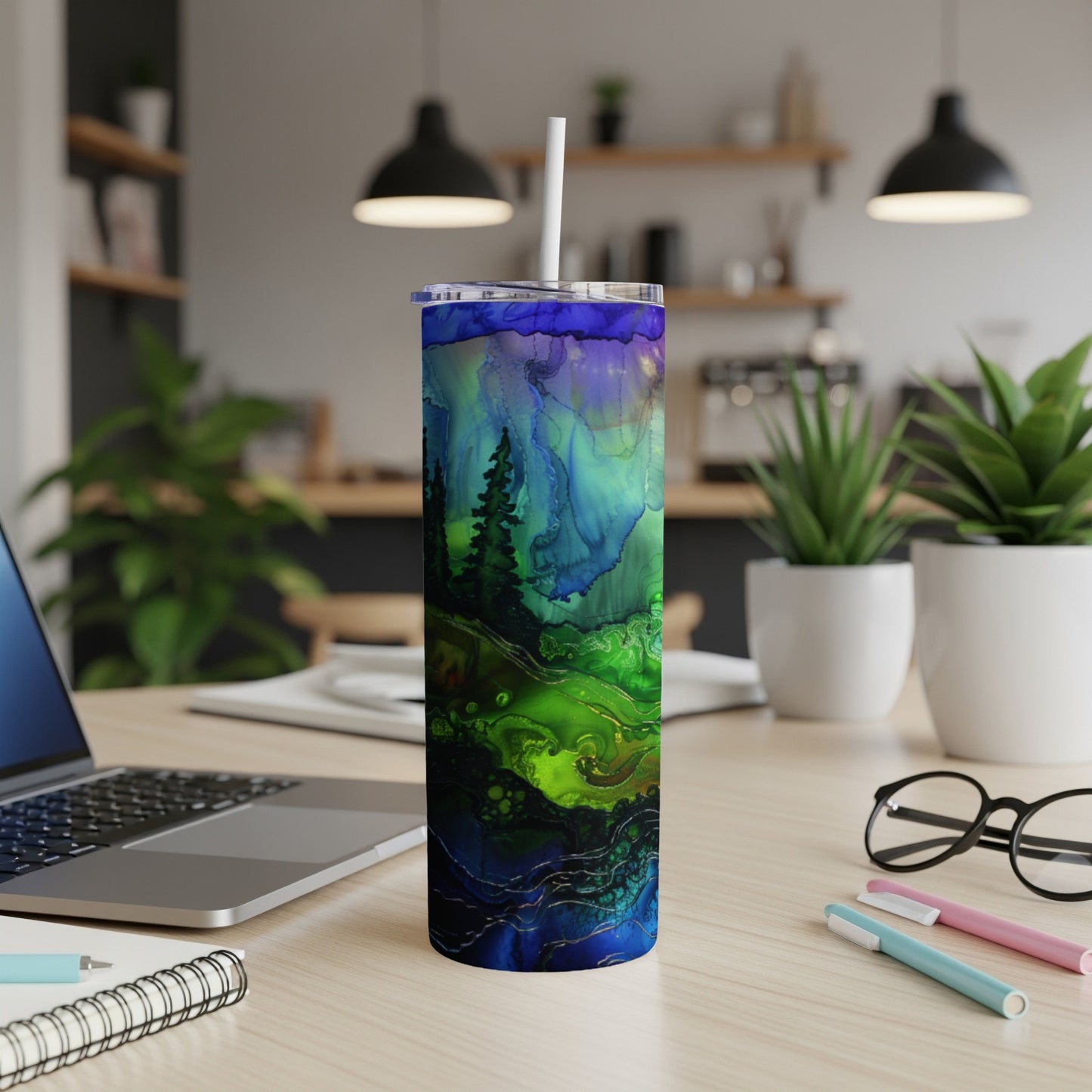 Blue and green abstract forest design on a tall tumbler with a straw.
