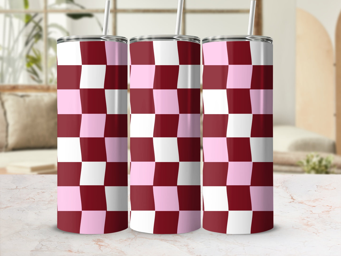 Three stainless steel tumblers with a pink and maroon checkered pattern.