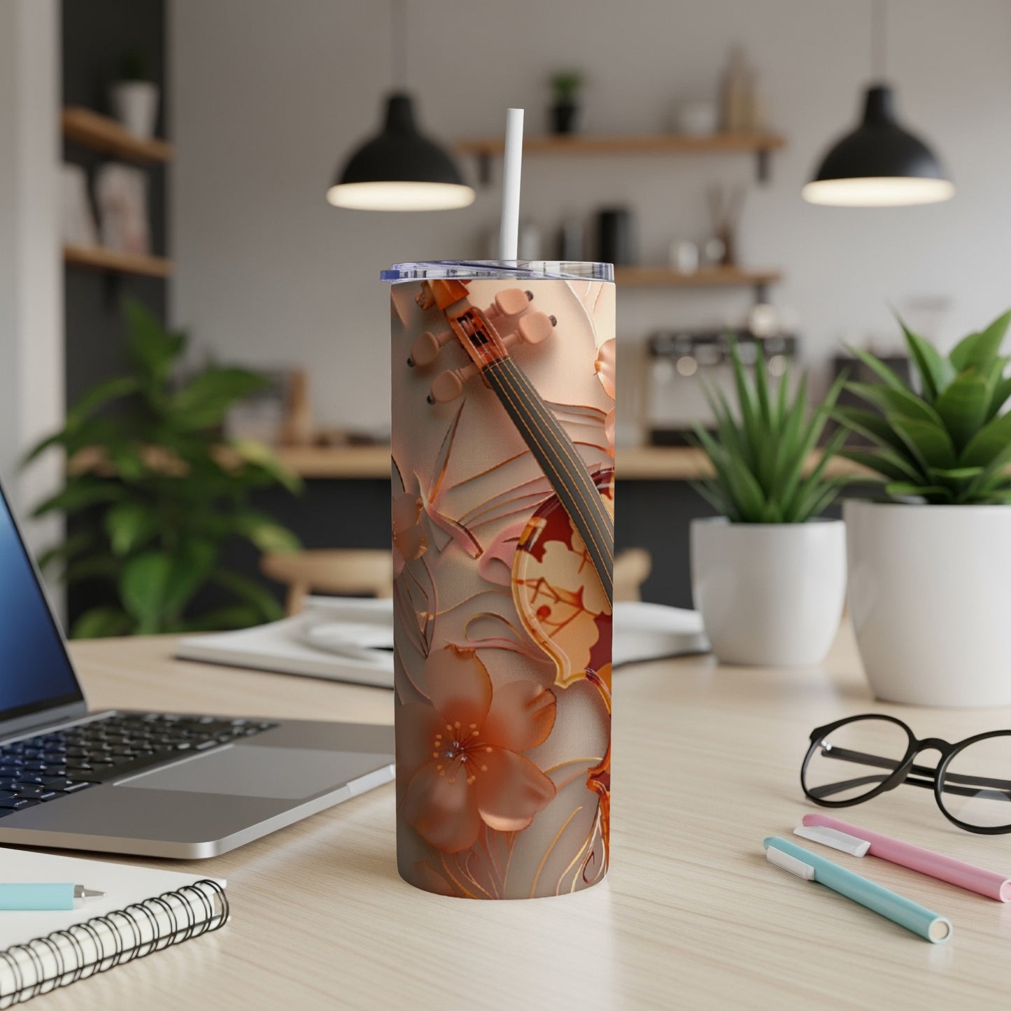 Floral and violin patterned stainless steel tumbler with a straw.