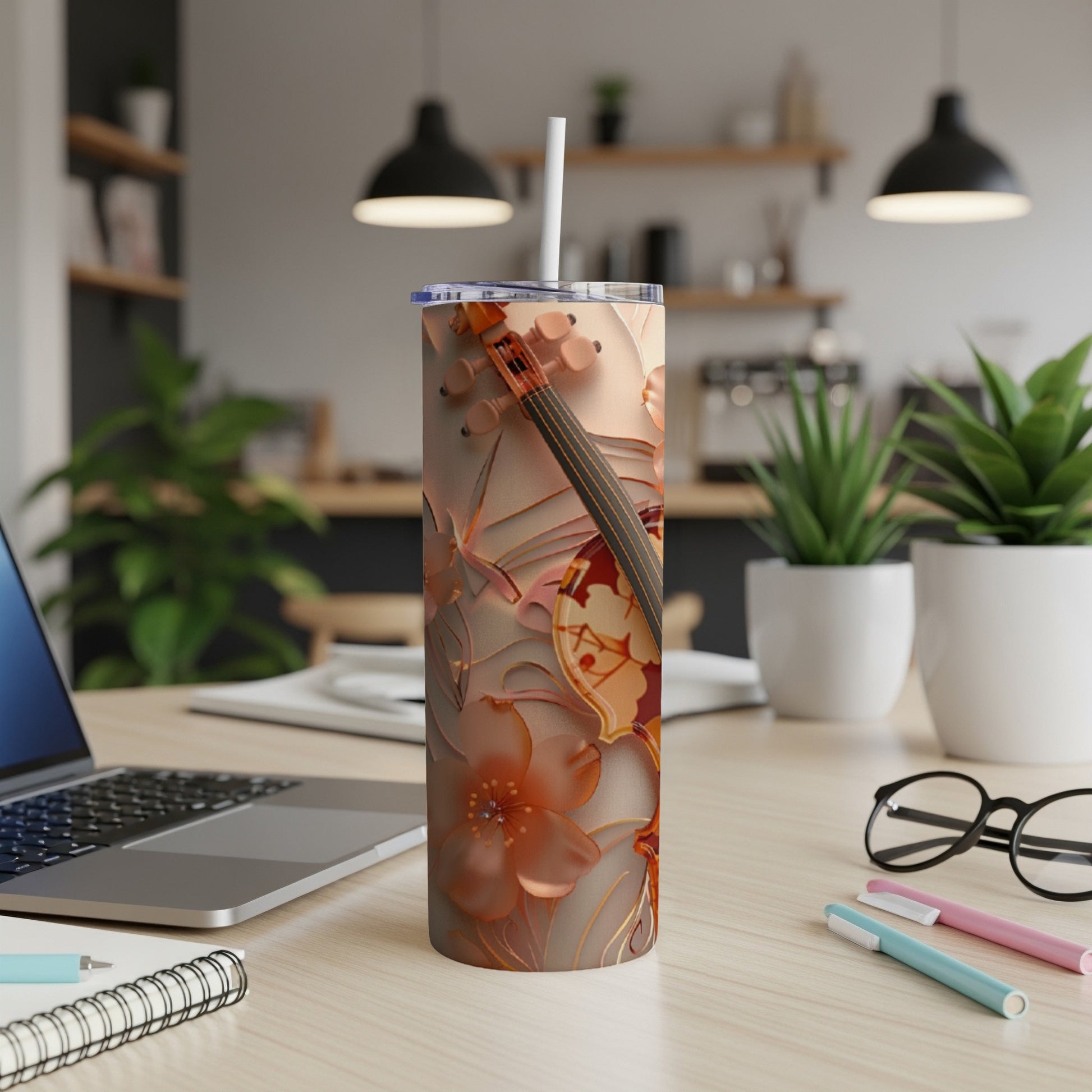 Floral and violin patterned stainless steel tumbler with a straw.