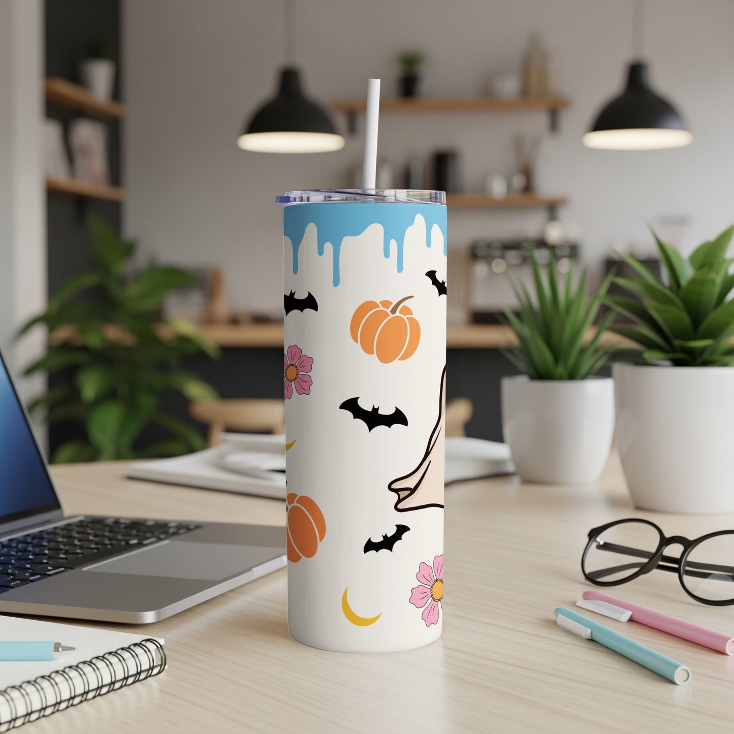 White tumbler with blue drips and Halloween icons: pumpkins, bats, flowers, moon.