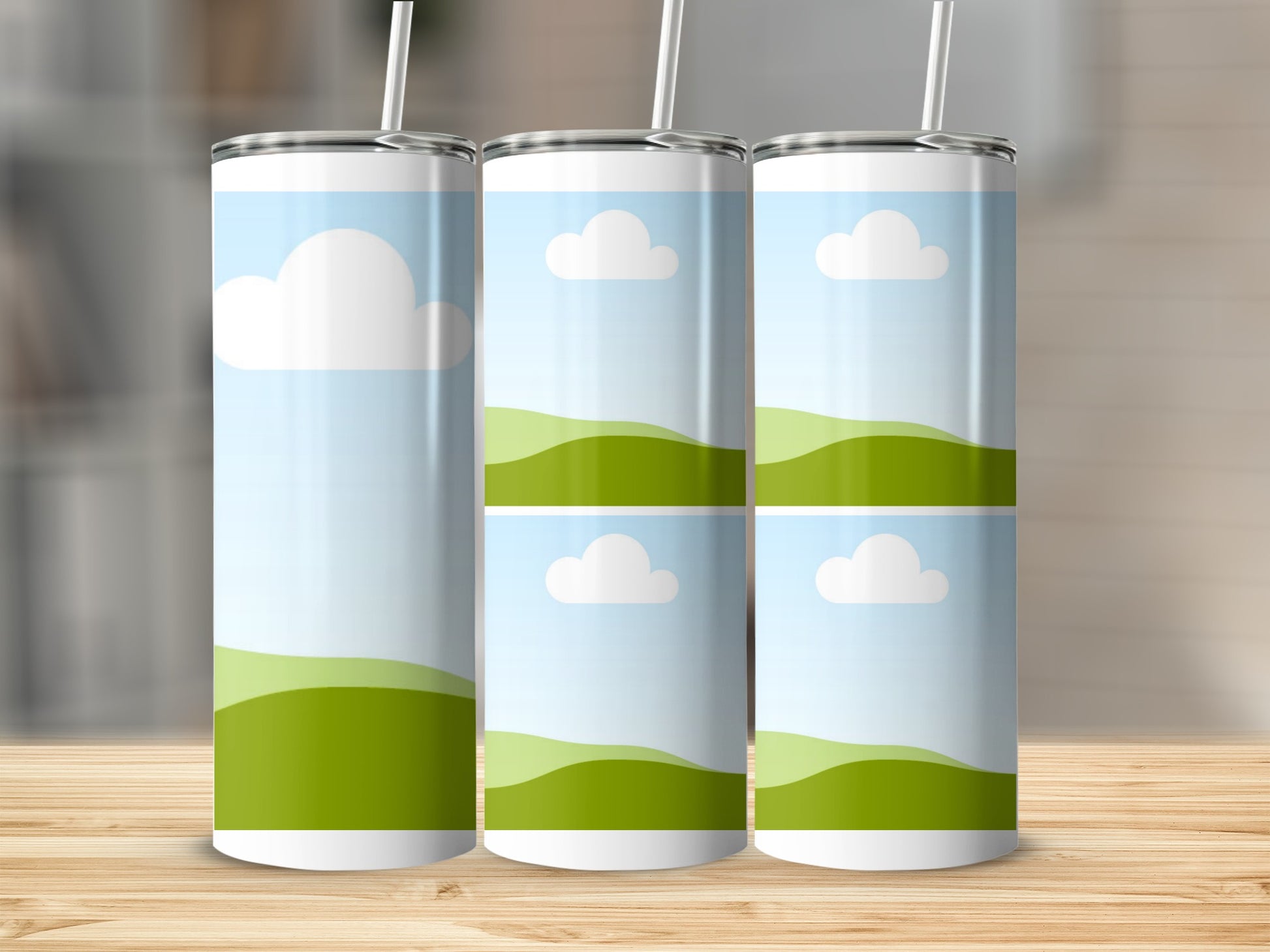 Three tumblers with a landscape design featuring green hills and clouds.