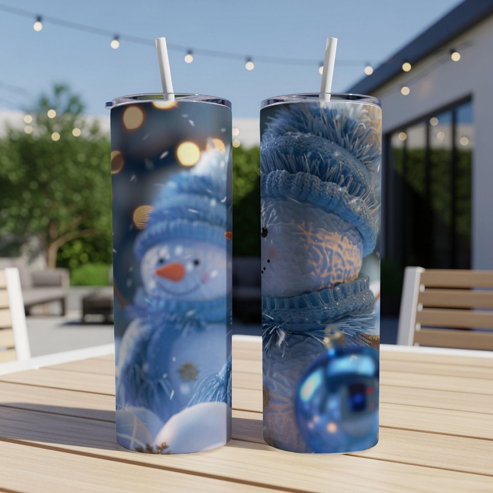 Two tumblers with snowman and blue scarf designs sit on a wooden table.