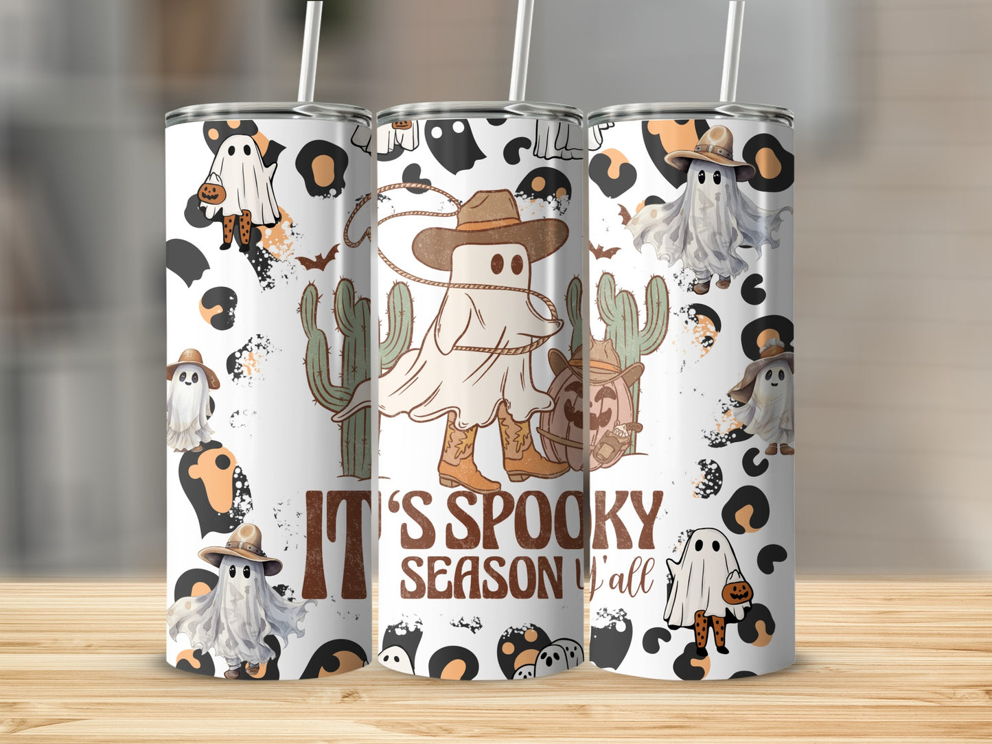 Tumbling cowboy ghosts, pumpkins, and cacti adorn tumblers reading "It's Spooky Season Y'all".