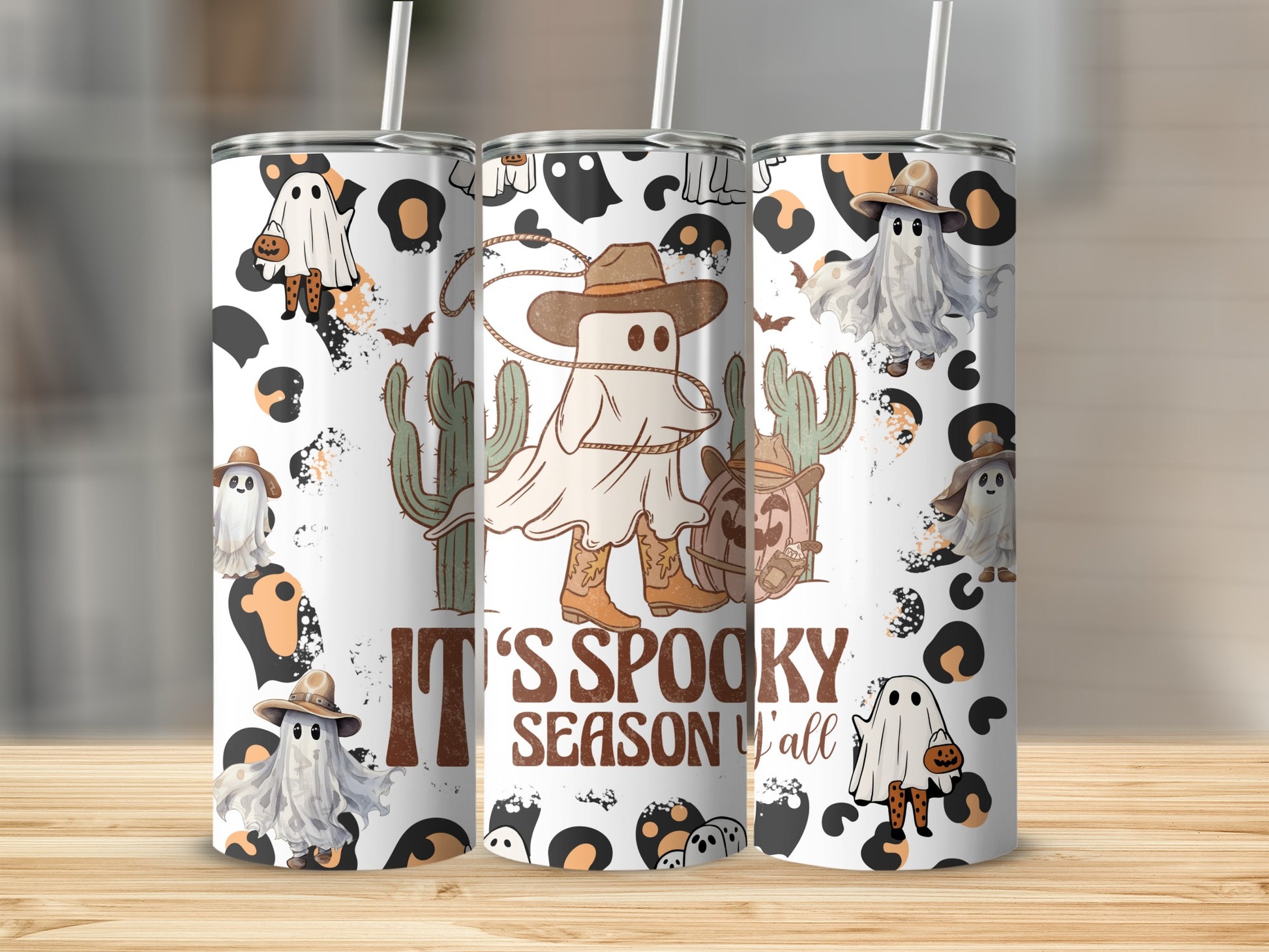 Tumbling cowboy ghosts, pumpkins, and cacti adorn tumblers reading "It's Spooky Season Y'all".