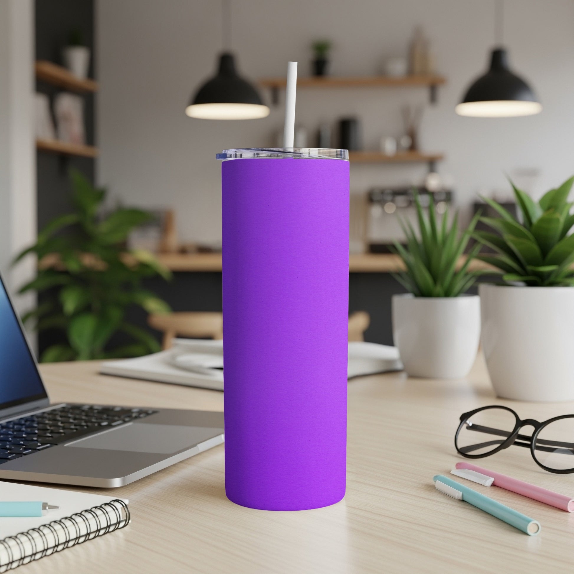 Purple stainless steel tumbler with straw on desk.