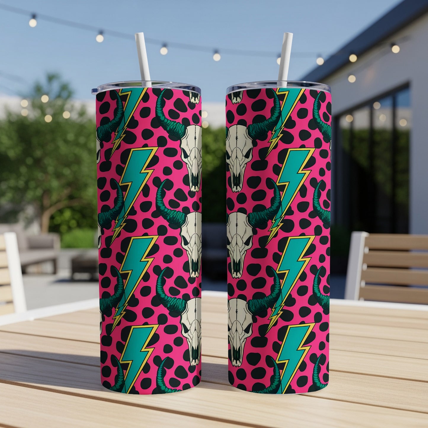 Pink tumbler with black and white cow skulls and turquoise lightning bolts.