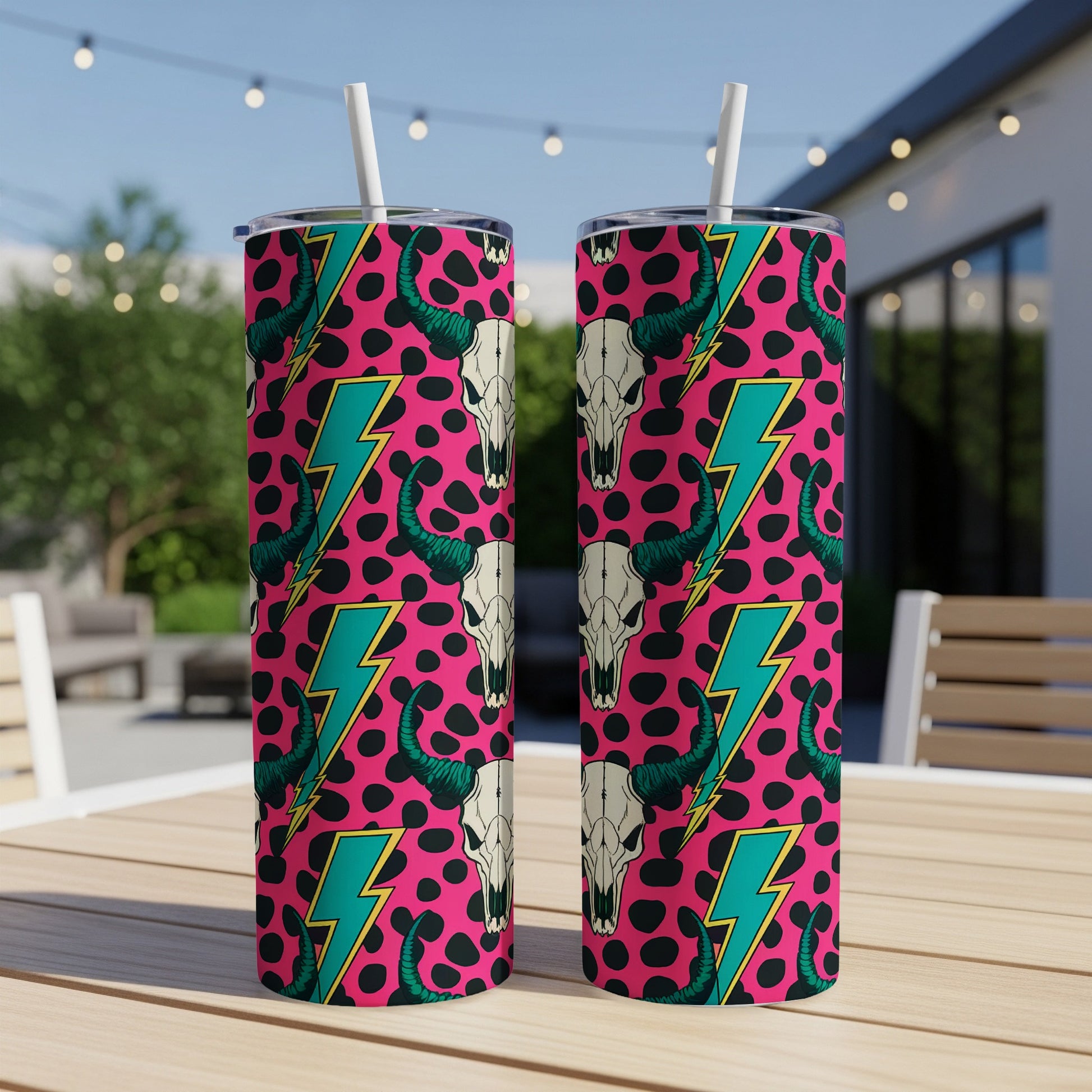 Pink tumbler with black and white cow skulls and turquoise lightning bolts.
