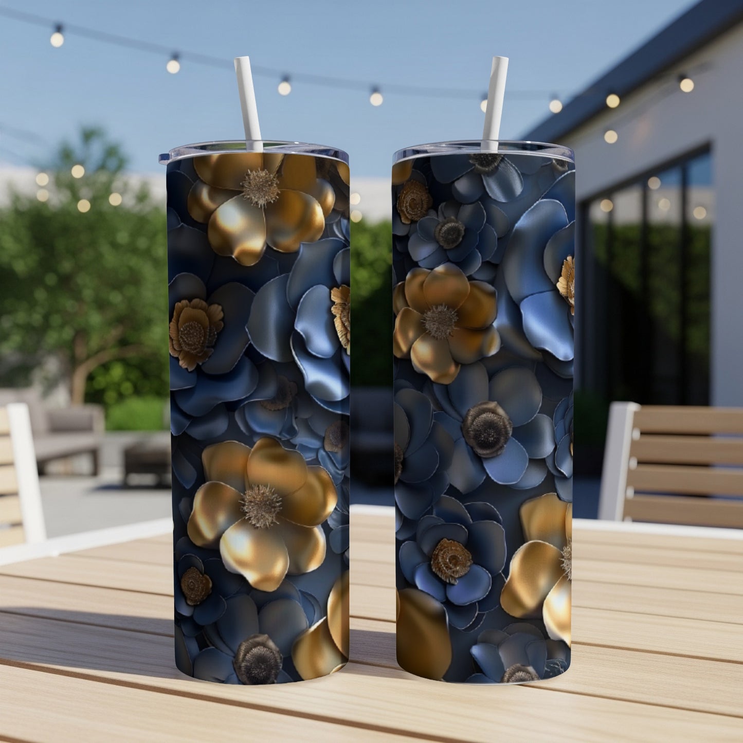 Two dark blue tumblers with gold floral patterns on a table outdoors.