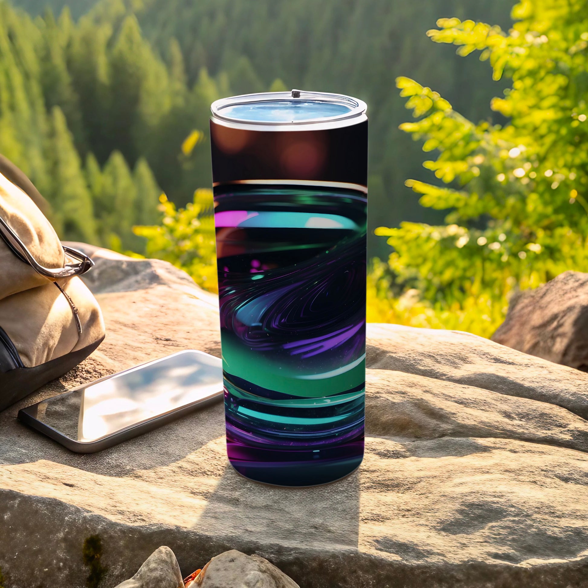 Tumbler with swirling purple and teal abstract design on an outdoor table.
