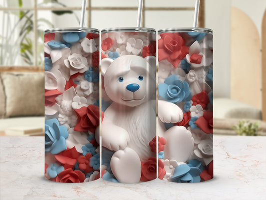 White teddy bear on a tumbler surrounded by red and blue flowers.