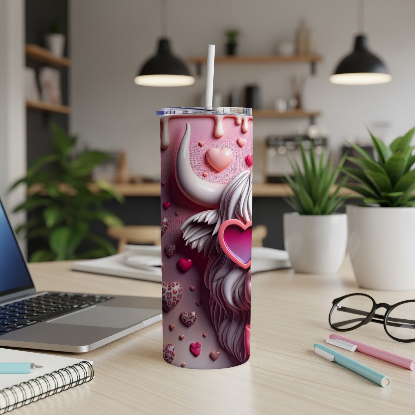 Pink tumbler with Highland cow and hearts, on a desk.