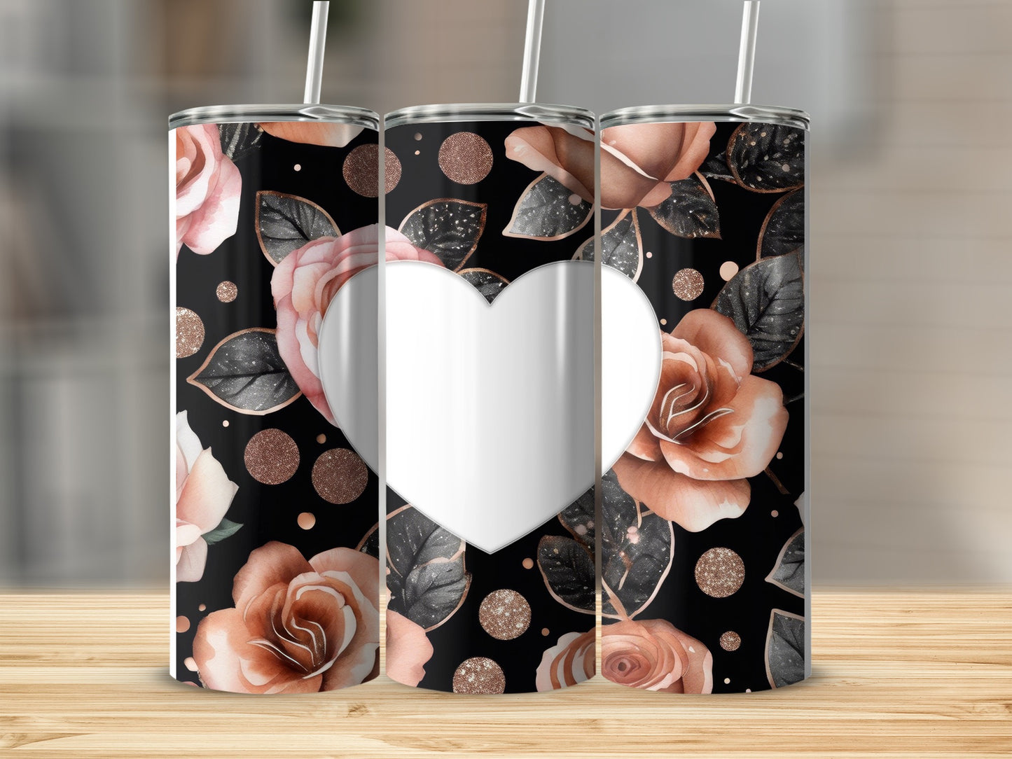 Three tumblers with rose and heart pattern on a wooden surface.