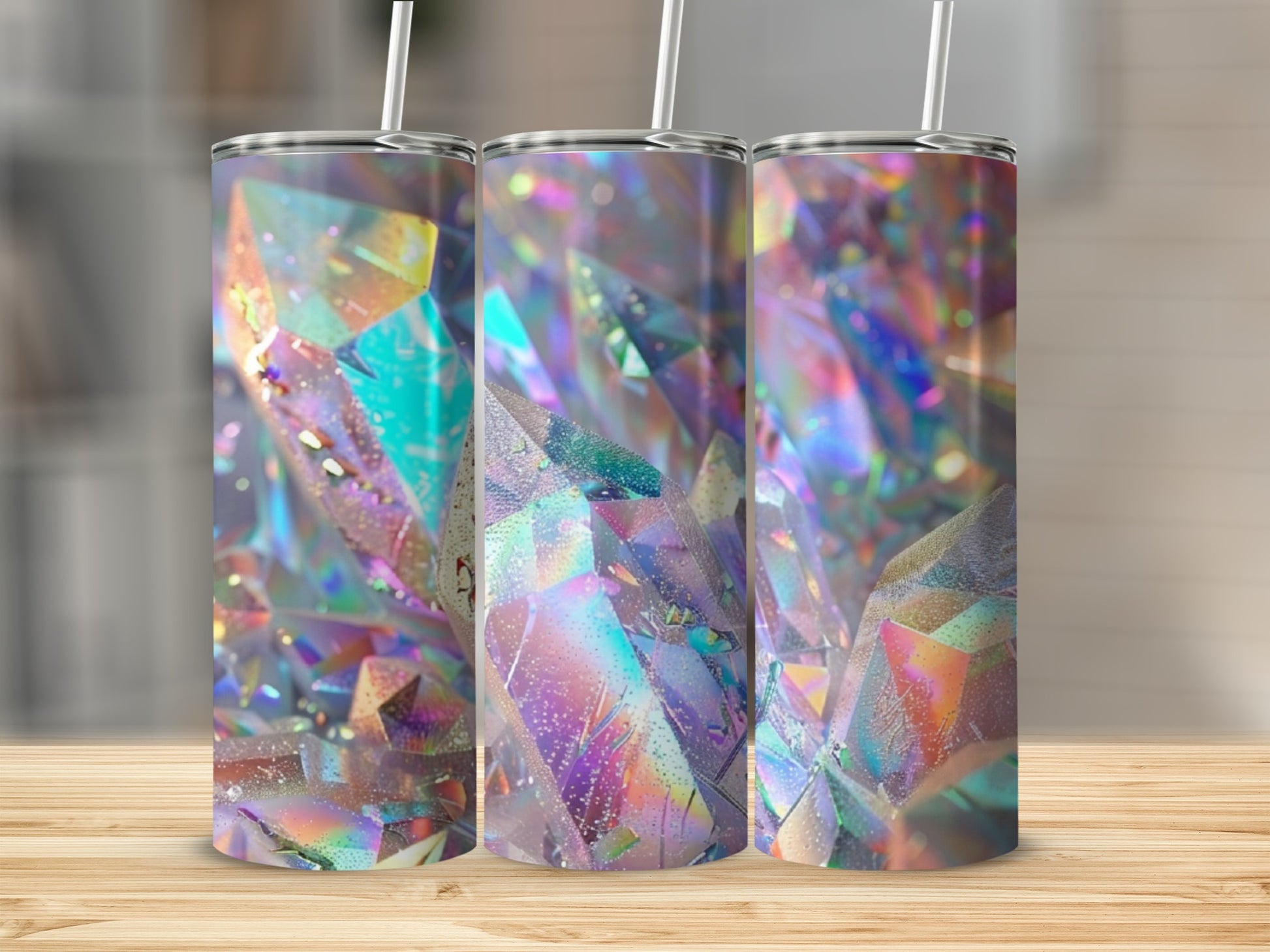 Three tumblers with iridescent crystal designs on a wooden surface.