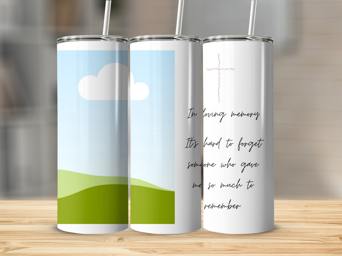 Three tumblers, one with a sky and clouds, two with memorial text and a cross.