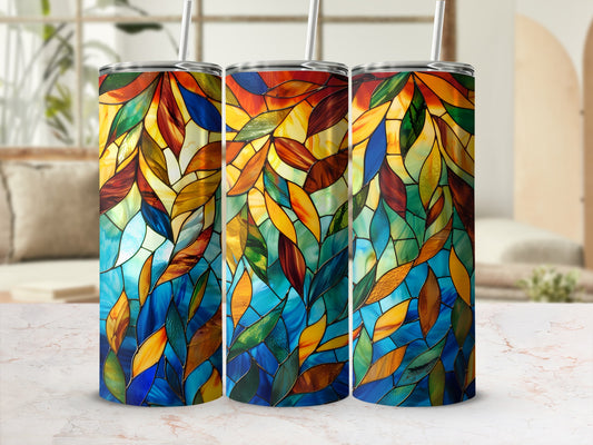 Three stained glass tumblers with colorful leaf patterns on a counter.