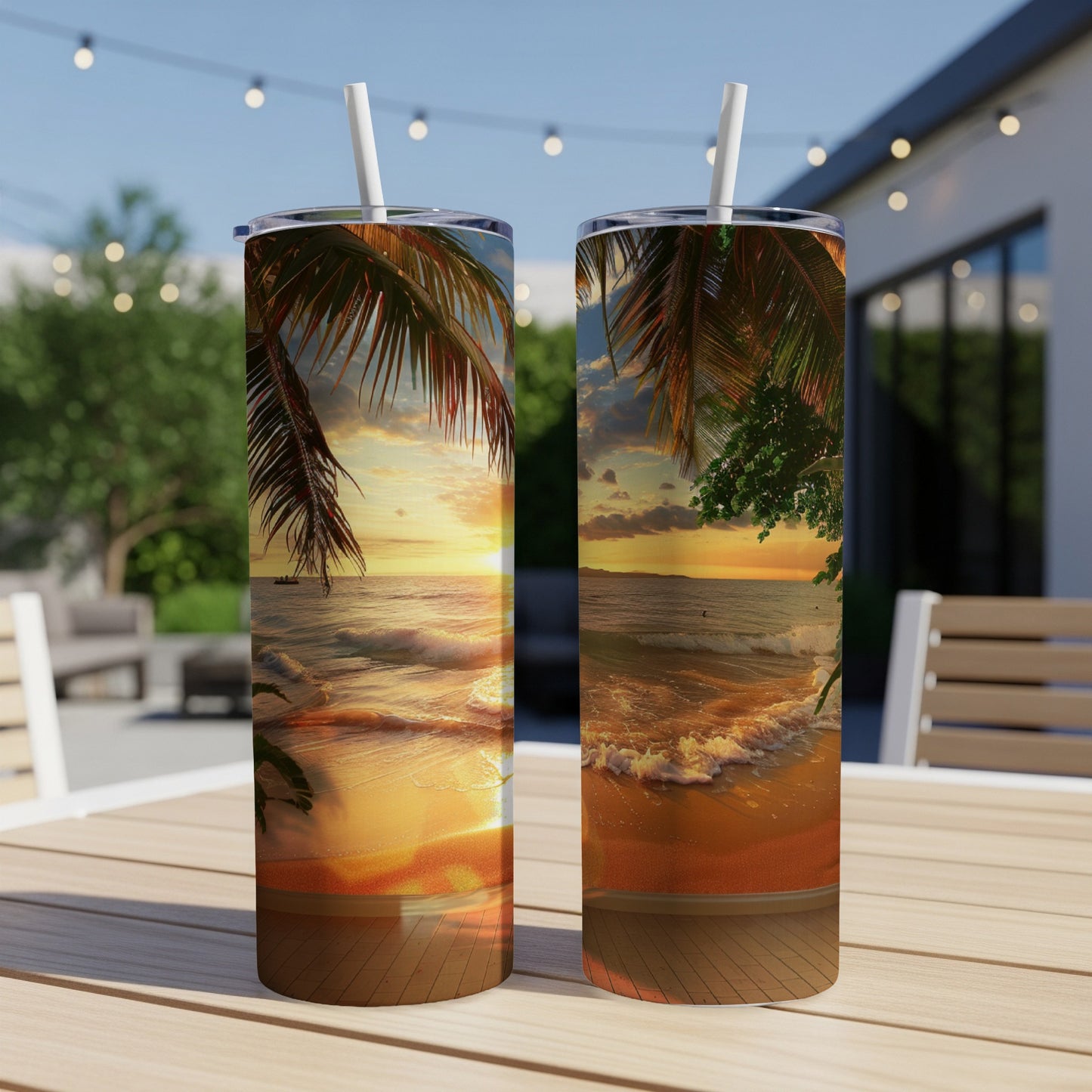 Two tumblers with a sunset beach scene on a wooden table outdoors.