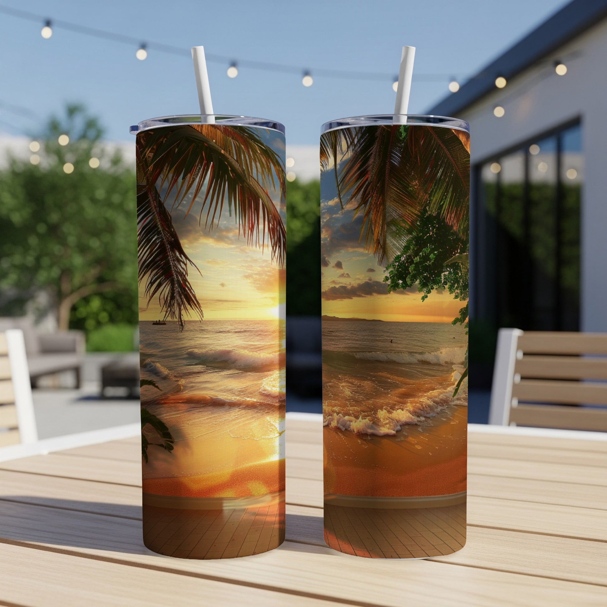 Two tumblers with a sunset beach scene on a wooden table outdoors.