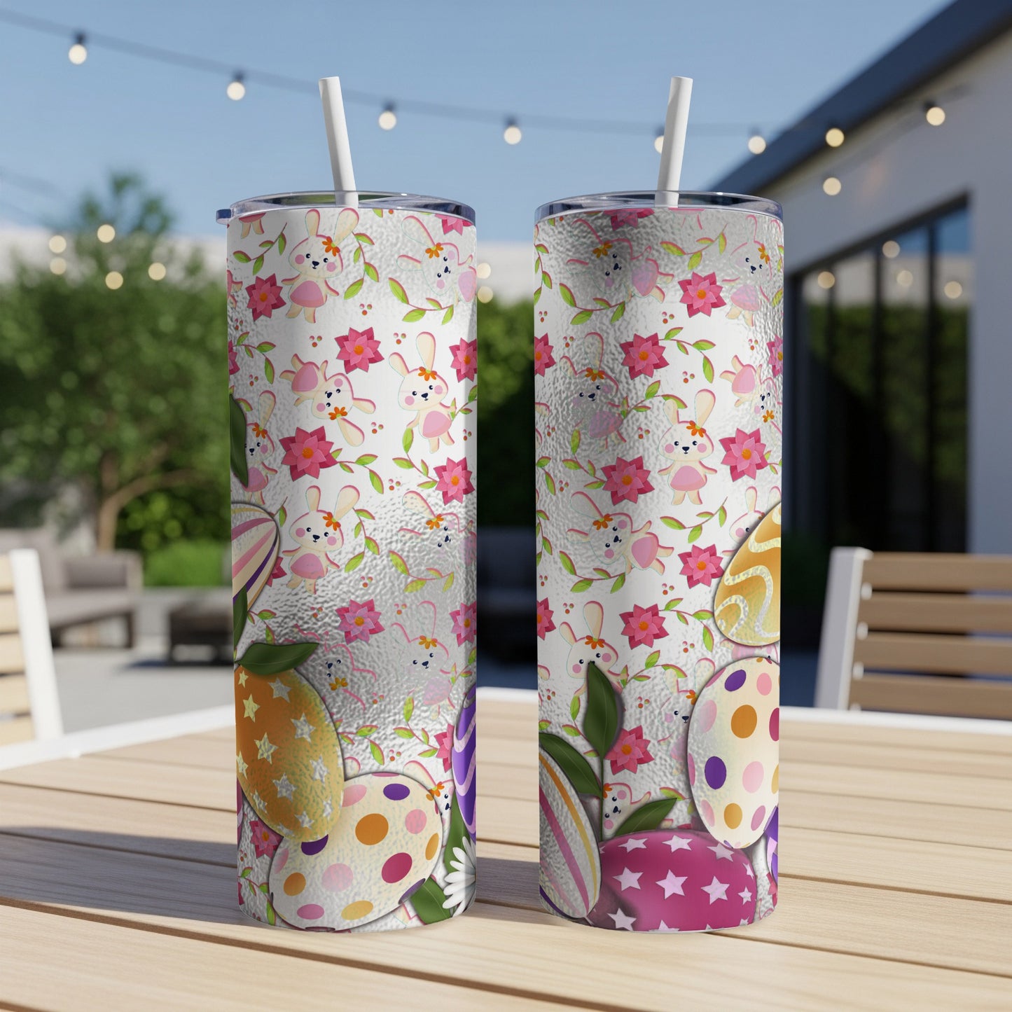 Two tumblers with Easter egg and bunny patterns on an outdoor table.