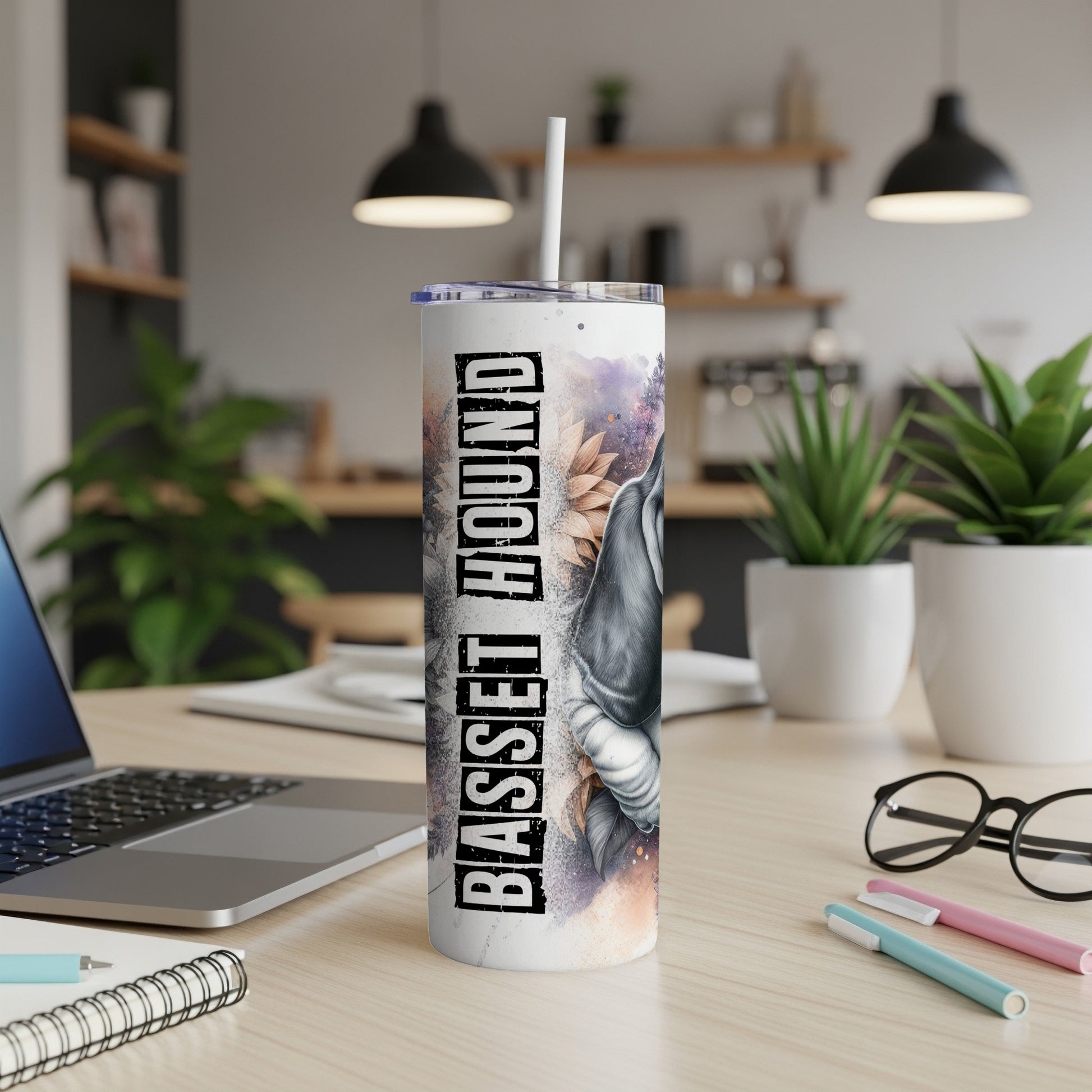 Basset Hound tumbler with floral accents on a desk with a laptop.
