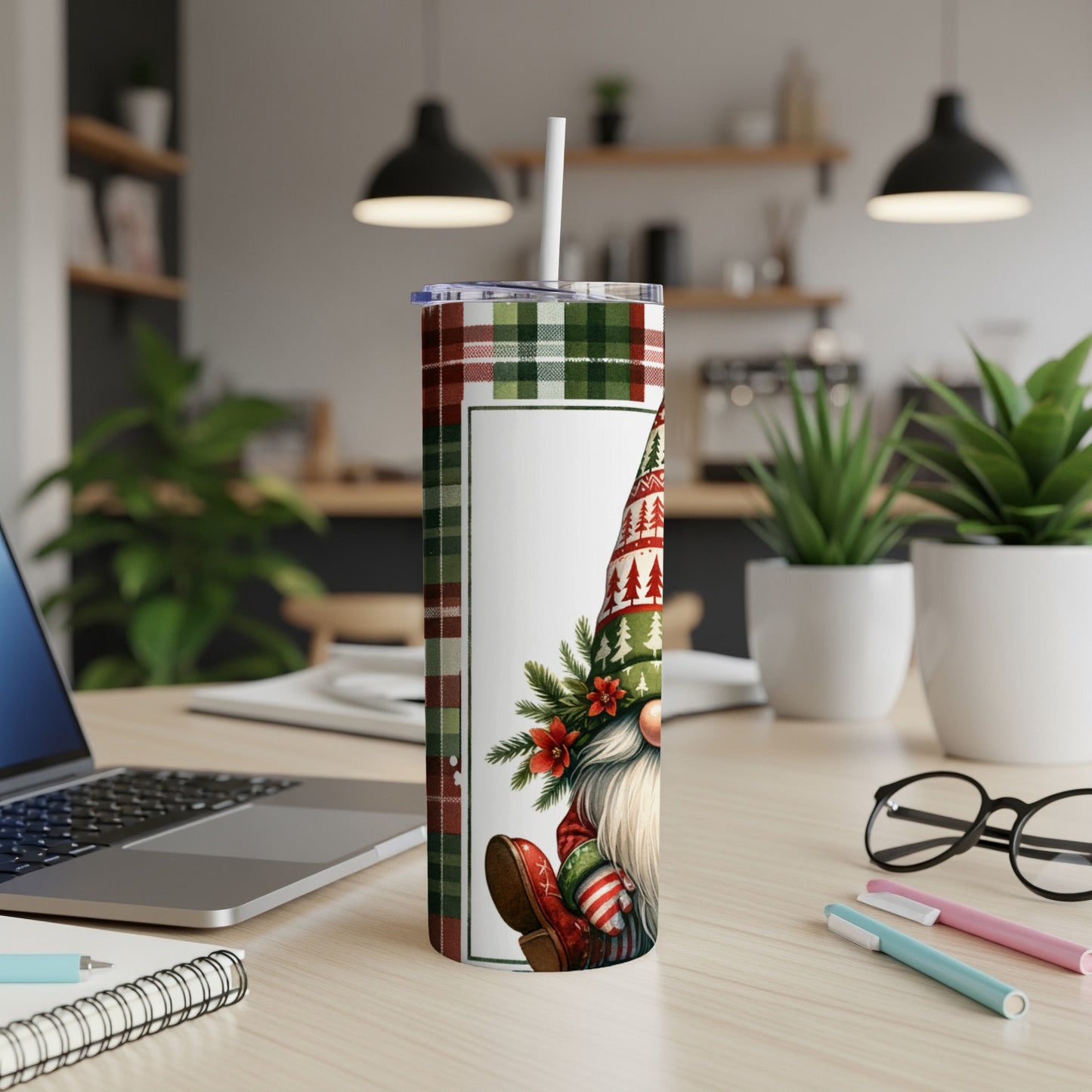 Christmas gnome tumbler with plaid accents on a desk.
