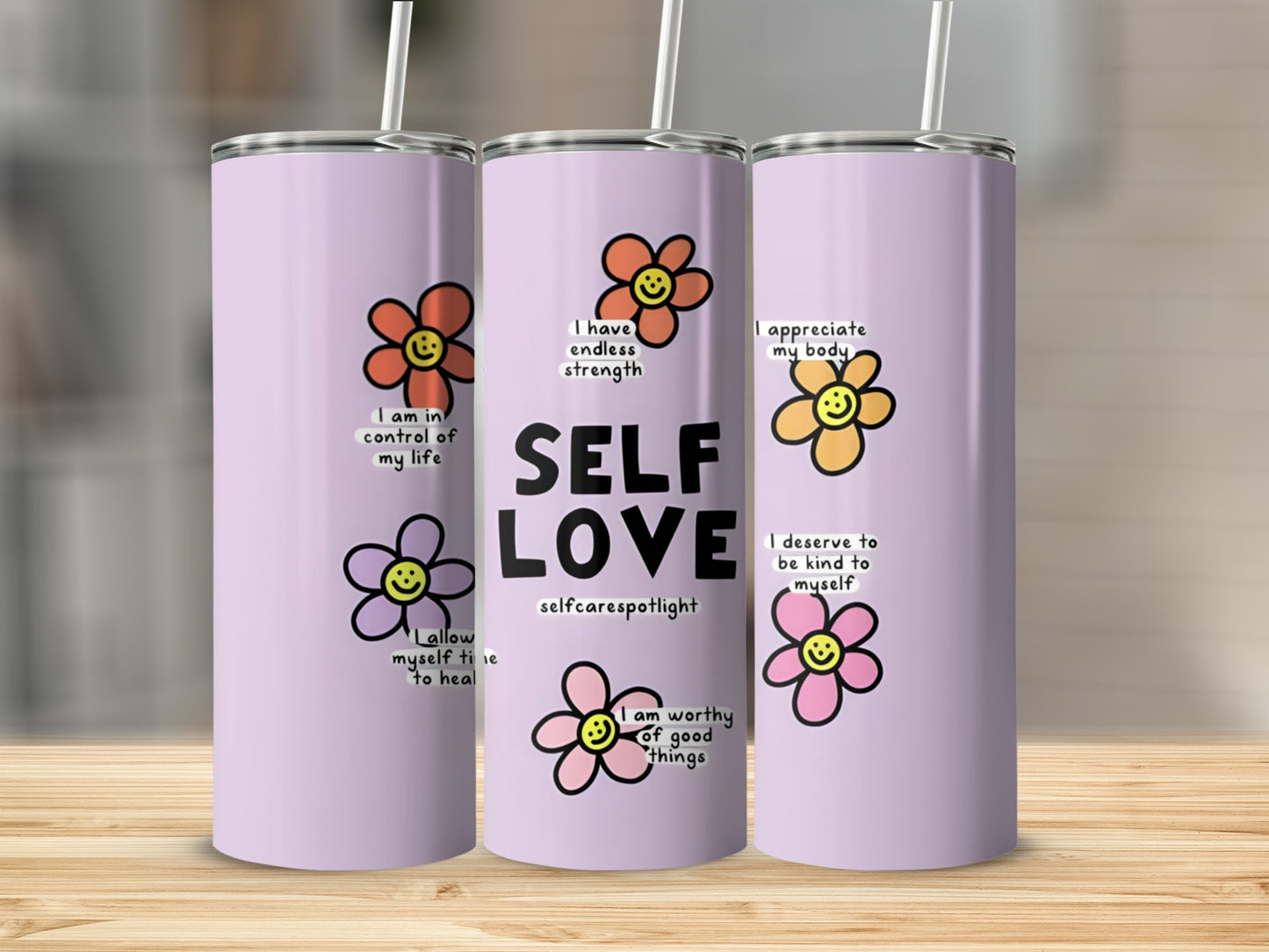 Three purple tumblers with flowers and positive affirmations like "SELF LOVE."