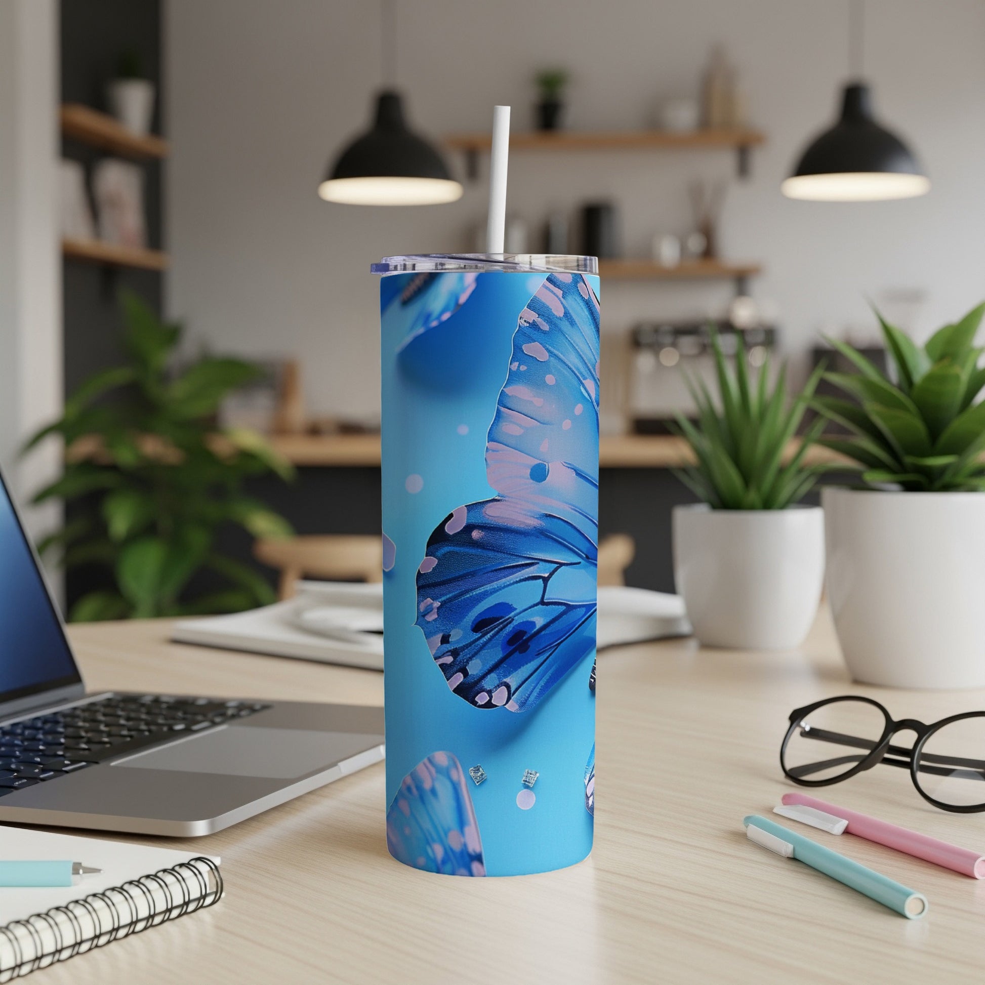 Blue butterfly pattern on a stainless steel tumbler with a straw.