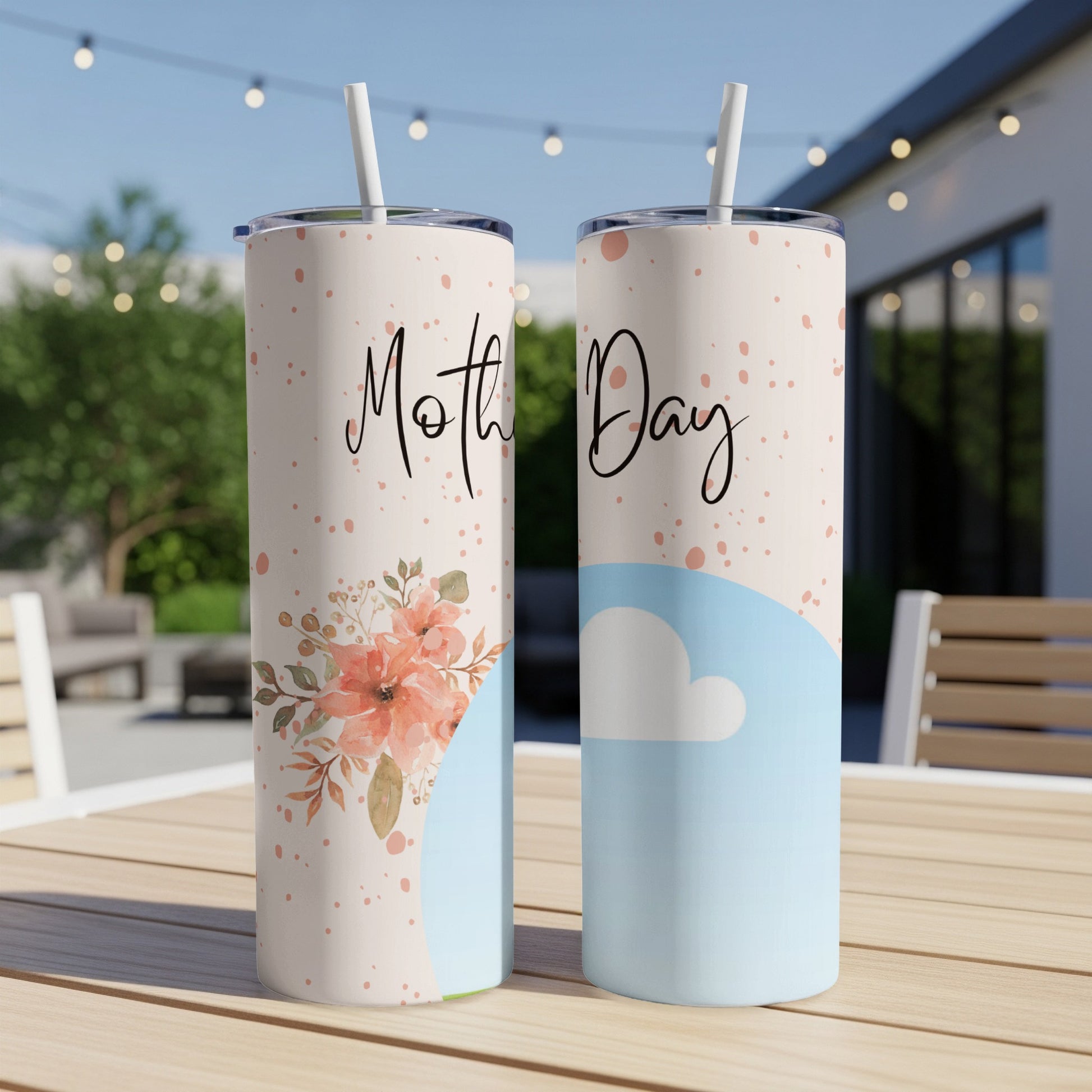 Two tumblers with "Mother Day" text, floral and cloud designs, on a table outdoors.