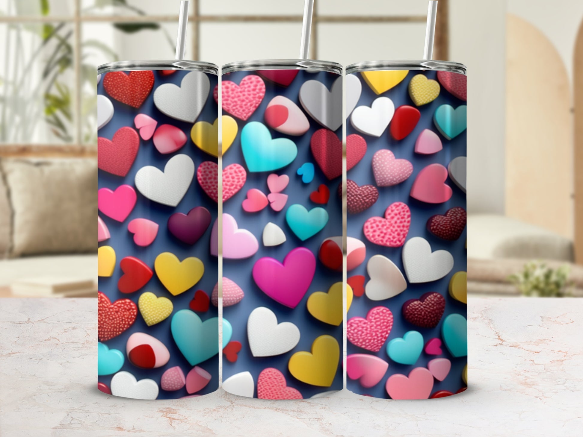 Three tumblers with a colorful heart pattern against a blurred background.